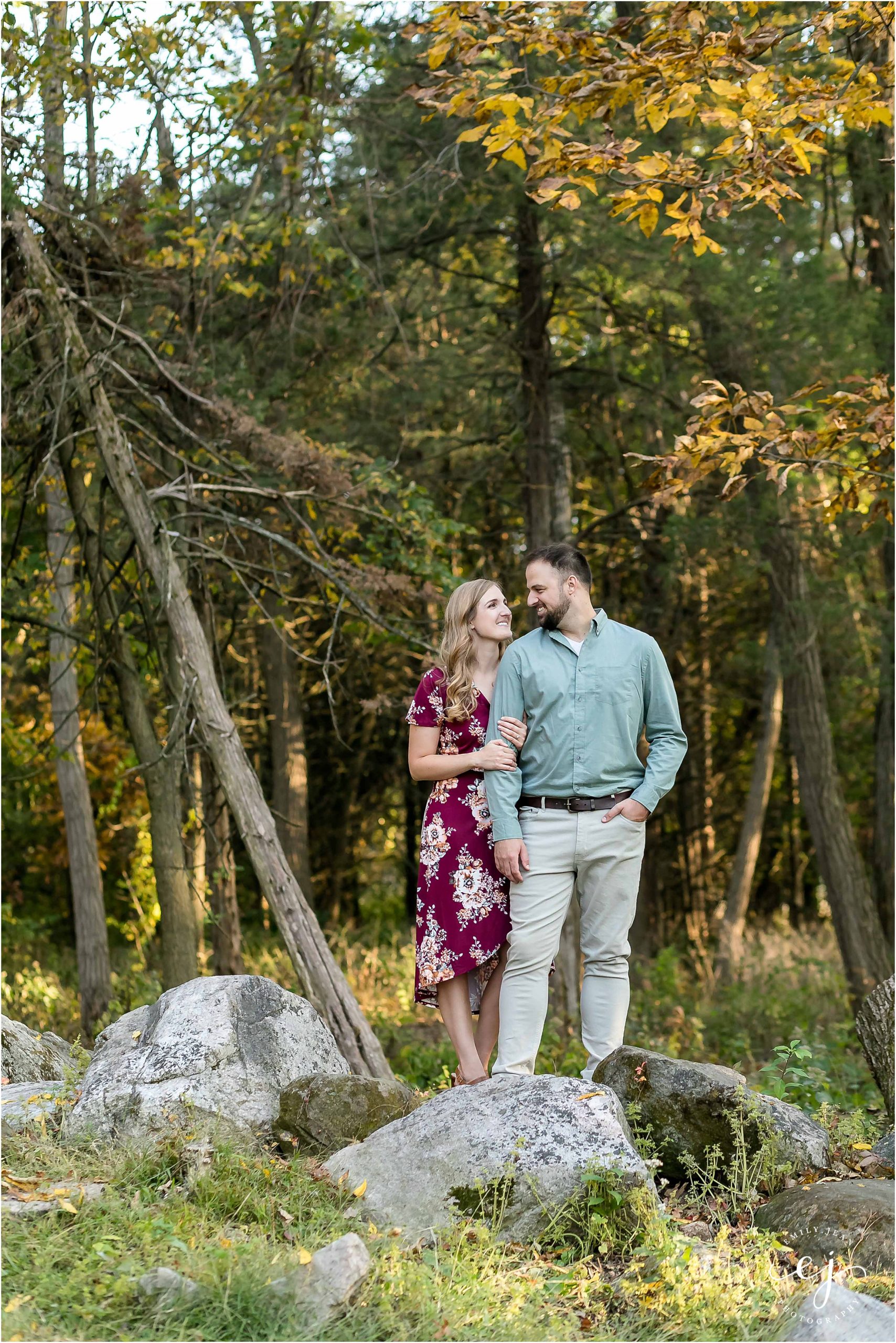 uw arboretum engagement session photographer wisconsin smiling at camera hugging large rocks standing