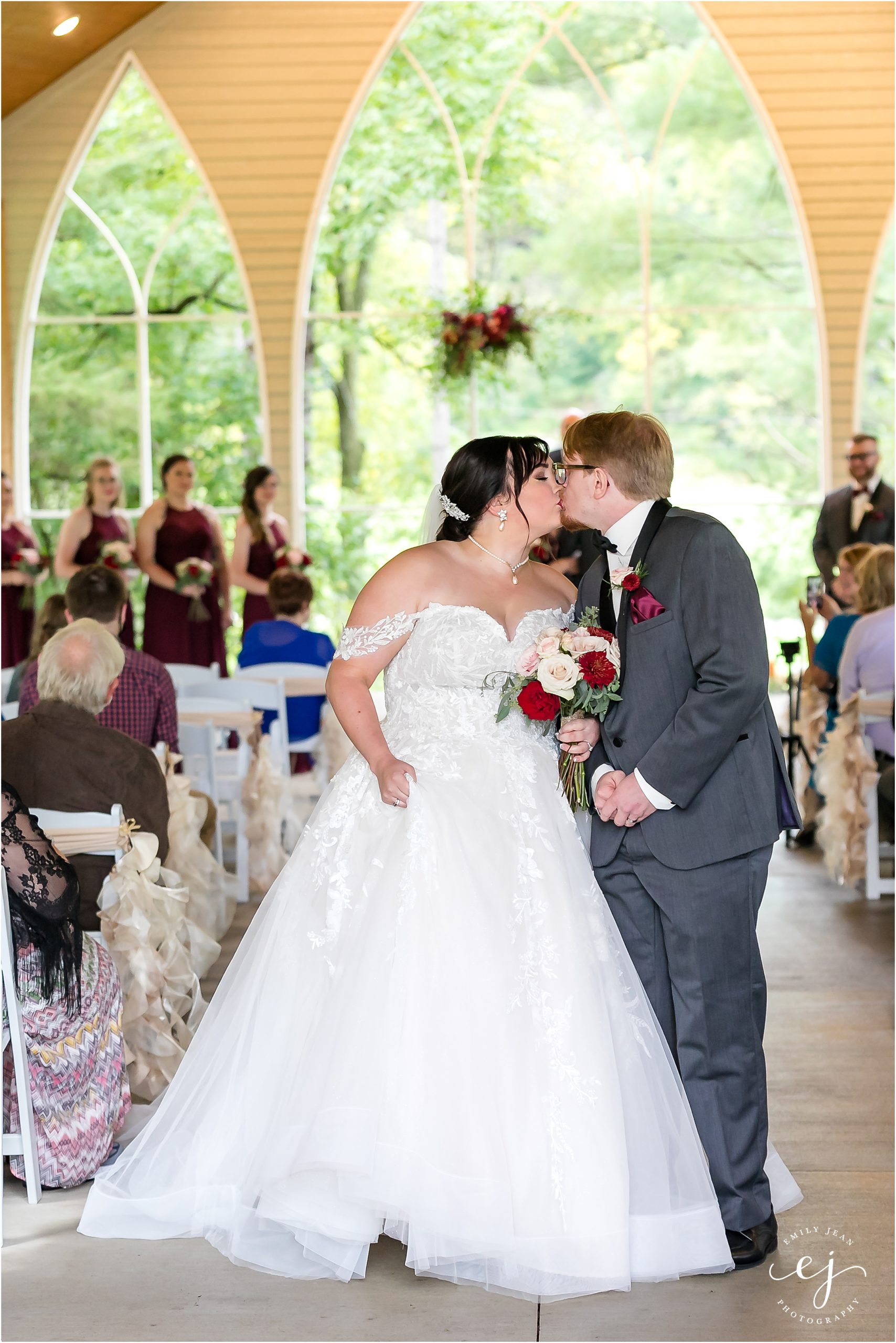 bride and groom kiss at the end of the aisle at open air chapel winnebago springs wedding caledonia minnesota