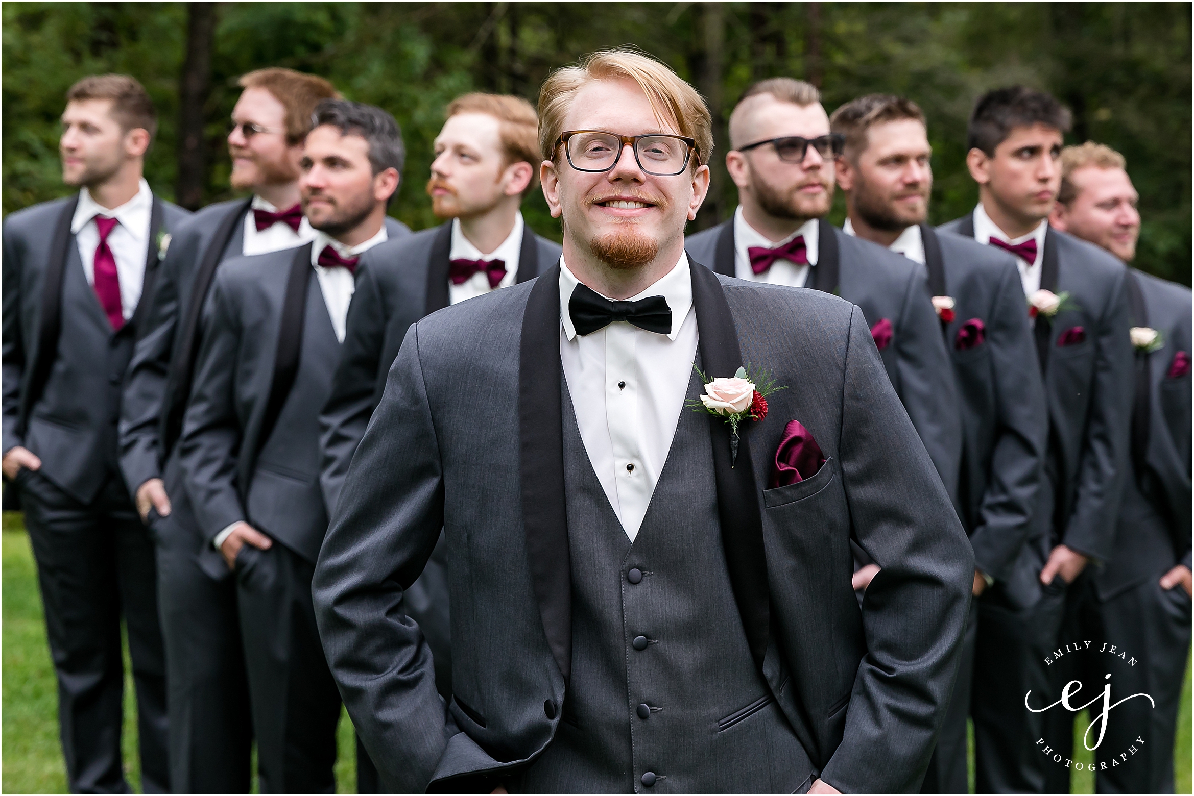 grey tux with black lapel 3 piece suite tuxedo groom with pink boutonniere flying v with groomsmen