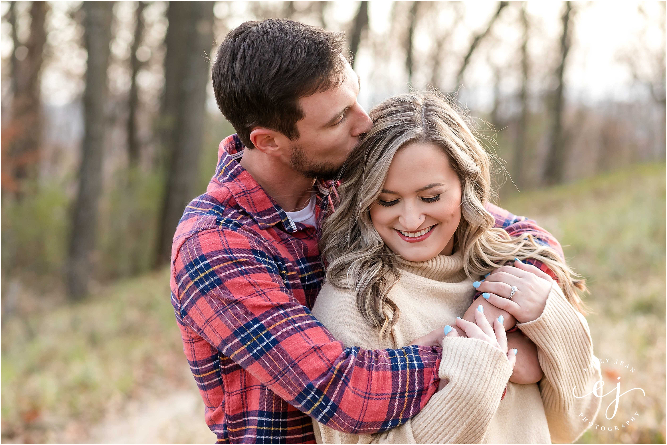 grandad bluff engagement session woman and man kissing head flannel shirt and beige turtleneck sweater