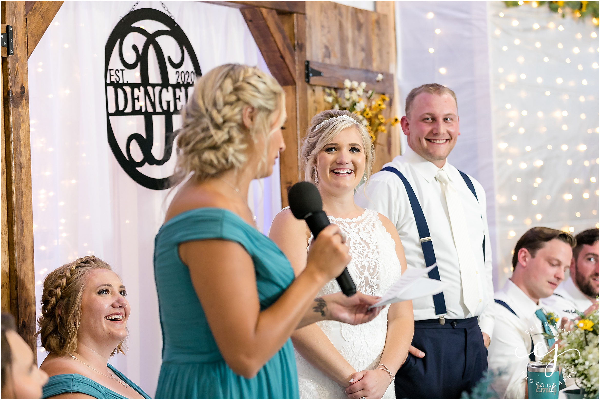 maid of honor speech with white twinkle light backdrop at head table