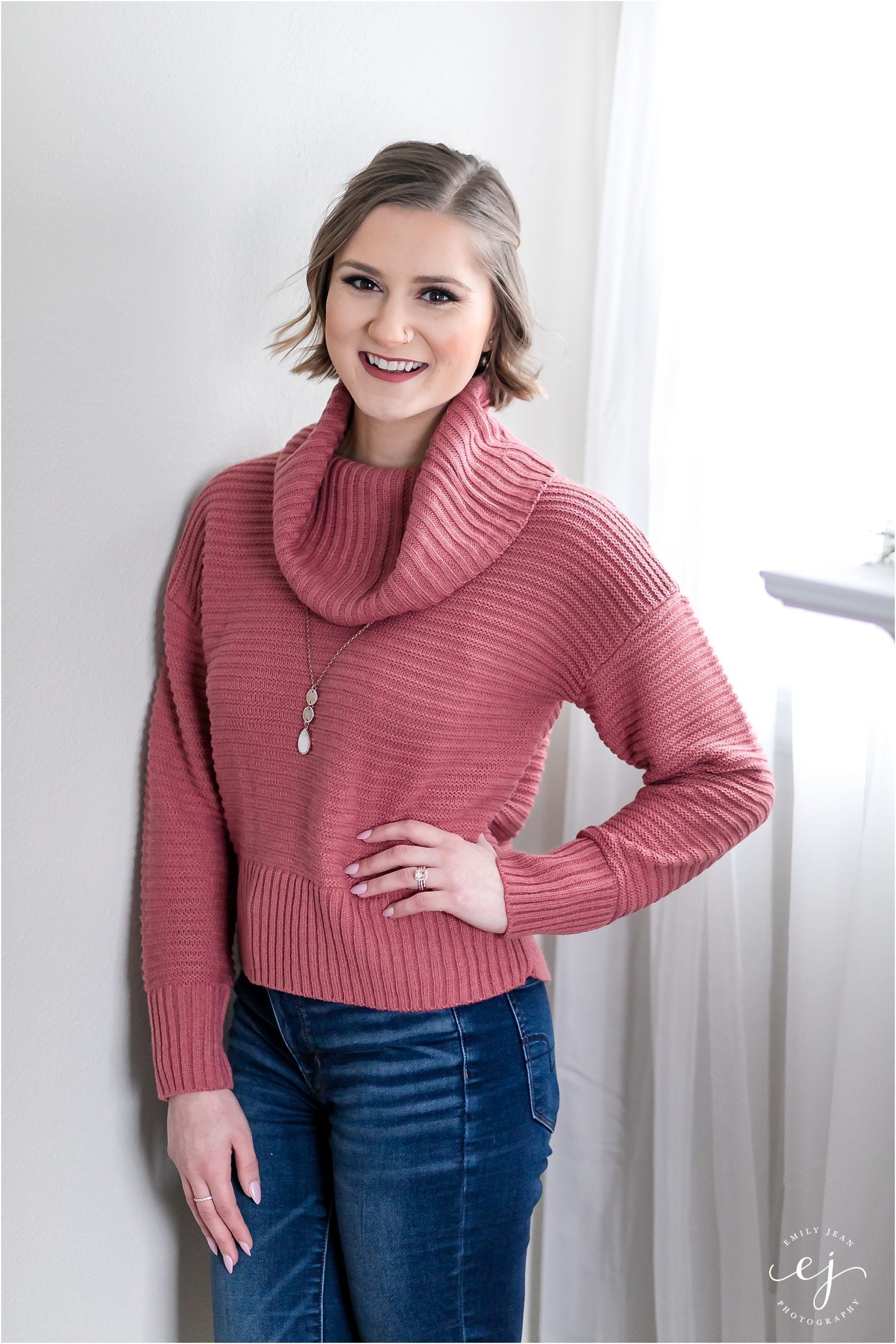lifestyle photos for makeup artist standing in a pink sweater headshot
