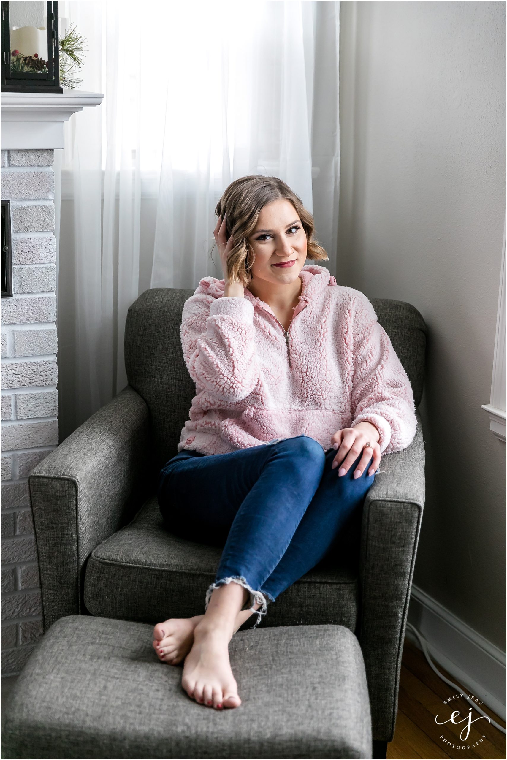 lifestyle photo of woman sitting on grey chair in pink fluffy sherpa