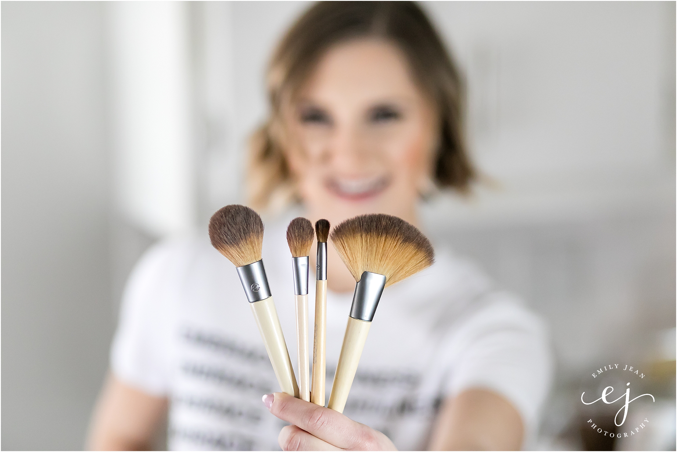 wisconsin makeup artist holding brushes with t shirt