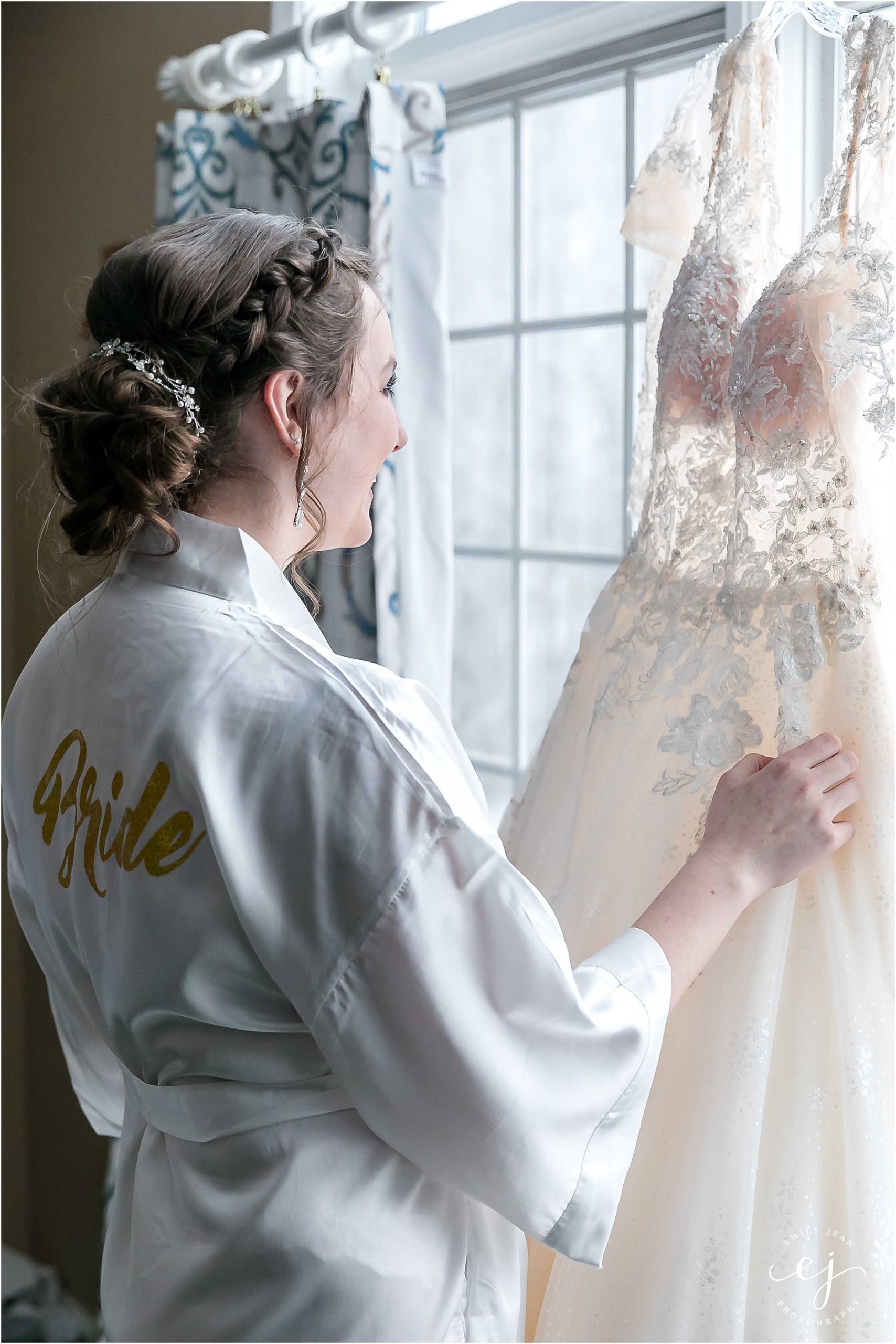 bride looking at dress hanging minnesota winter wedding photographer
