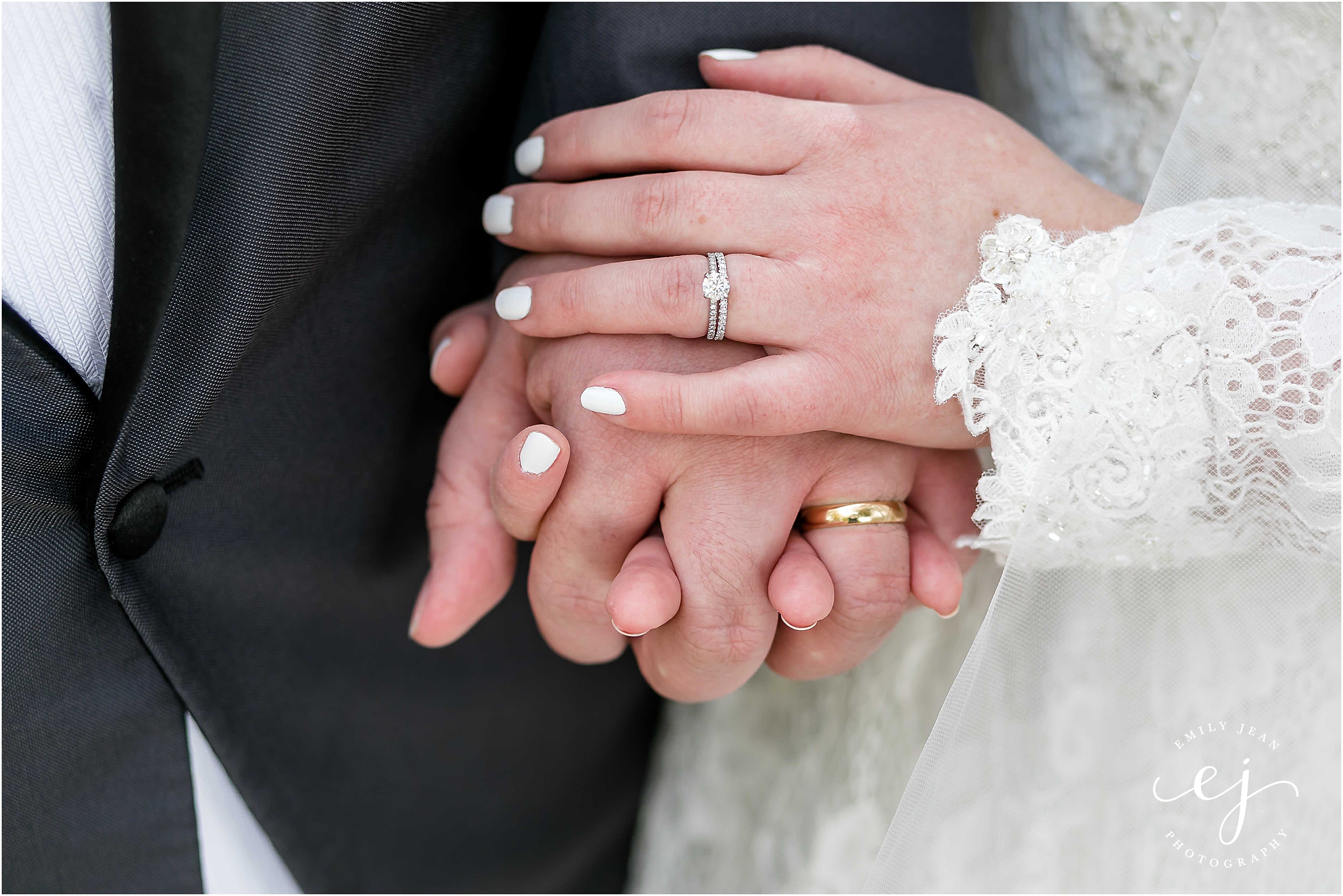 bride and groom hands holding blue nile ring