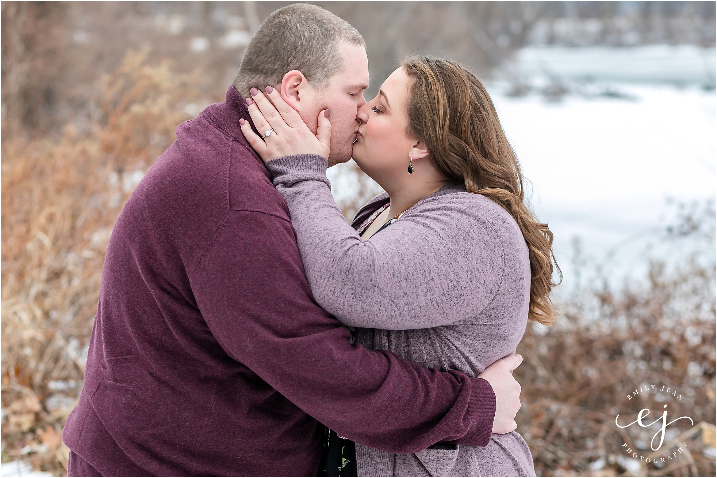 couple standing in snow engagement session wisconsin plus size couple kissing