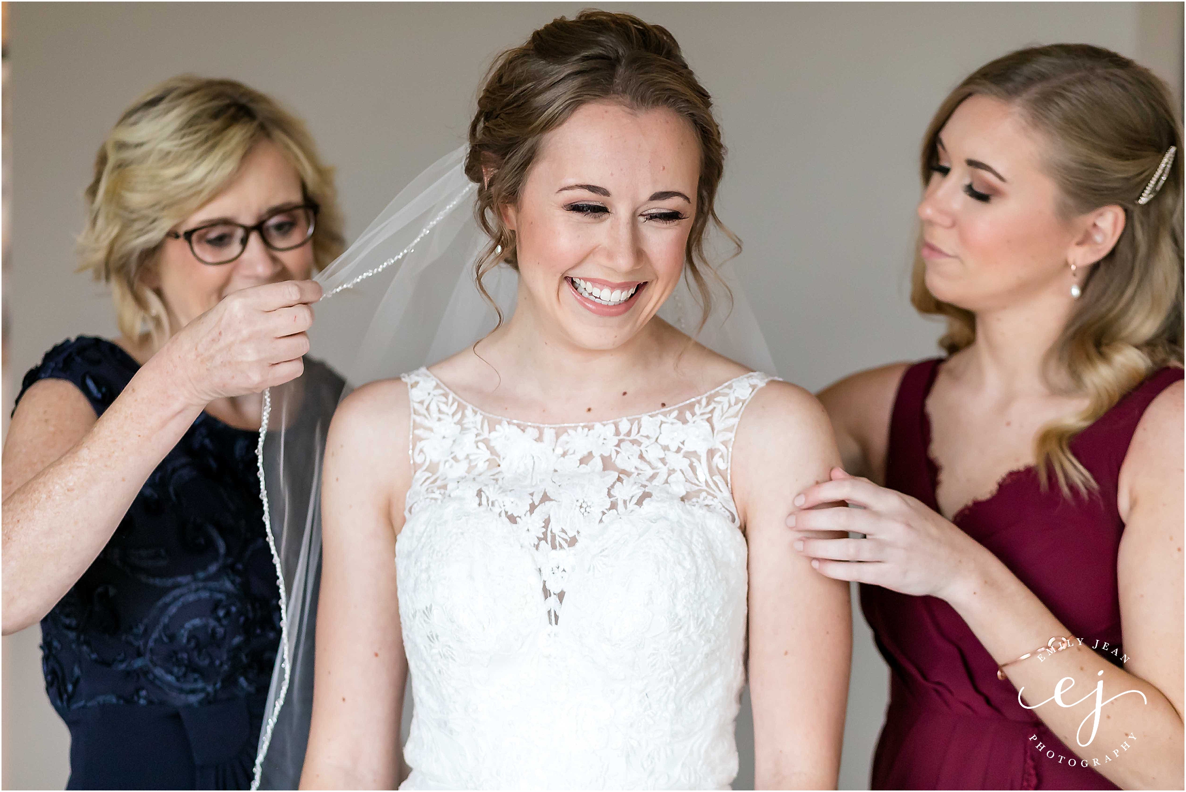 maid of honor putting veil in bride's hair with mom la crosse wisconsin