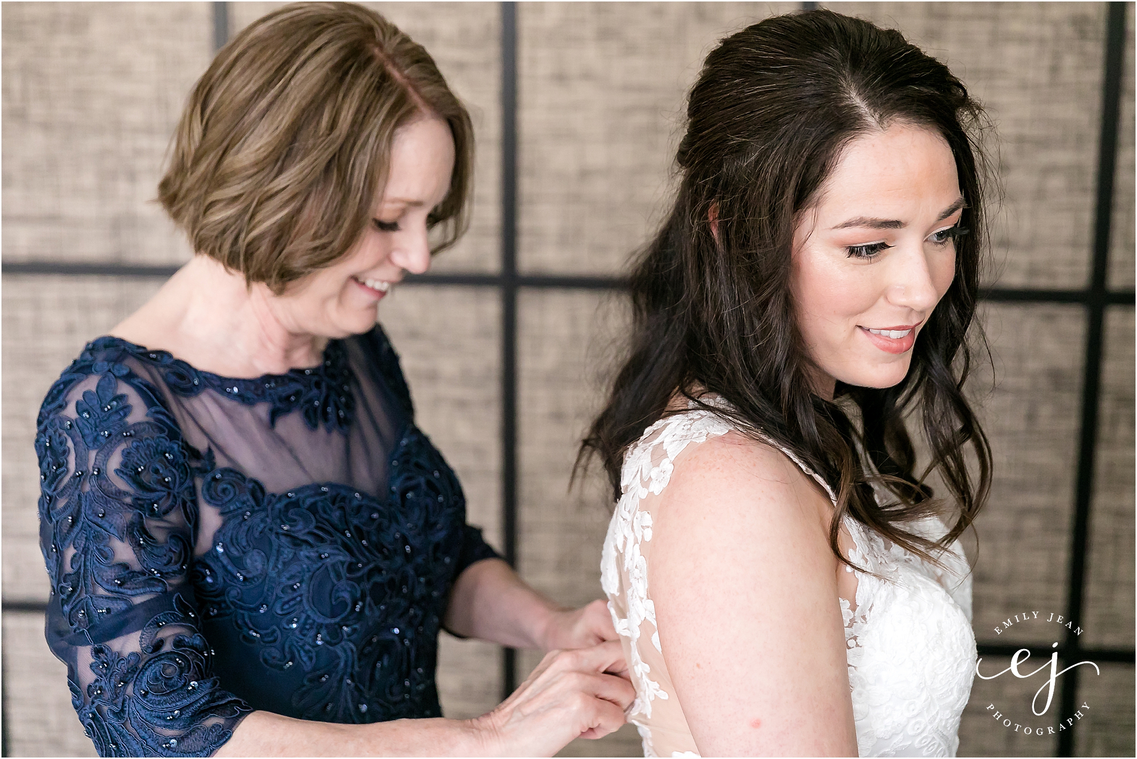 bride getting into dress with mom at charmant hotel