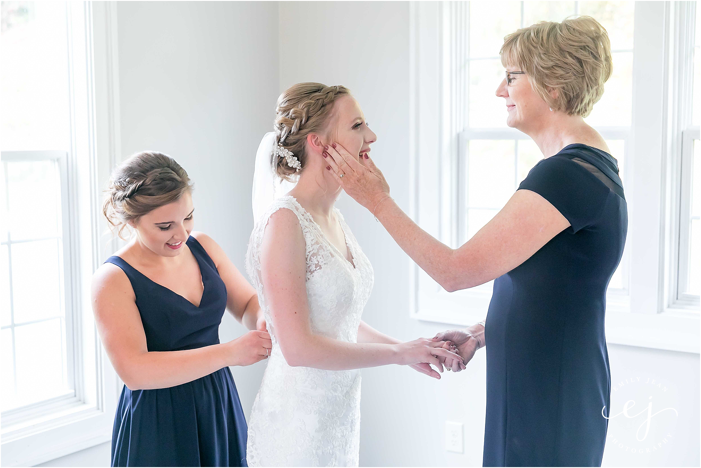bride getting in dress at edgewood farm and her mom wipes her tear