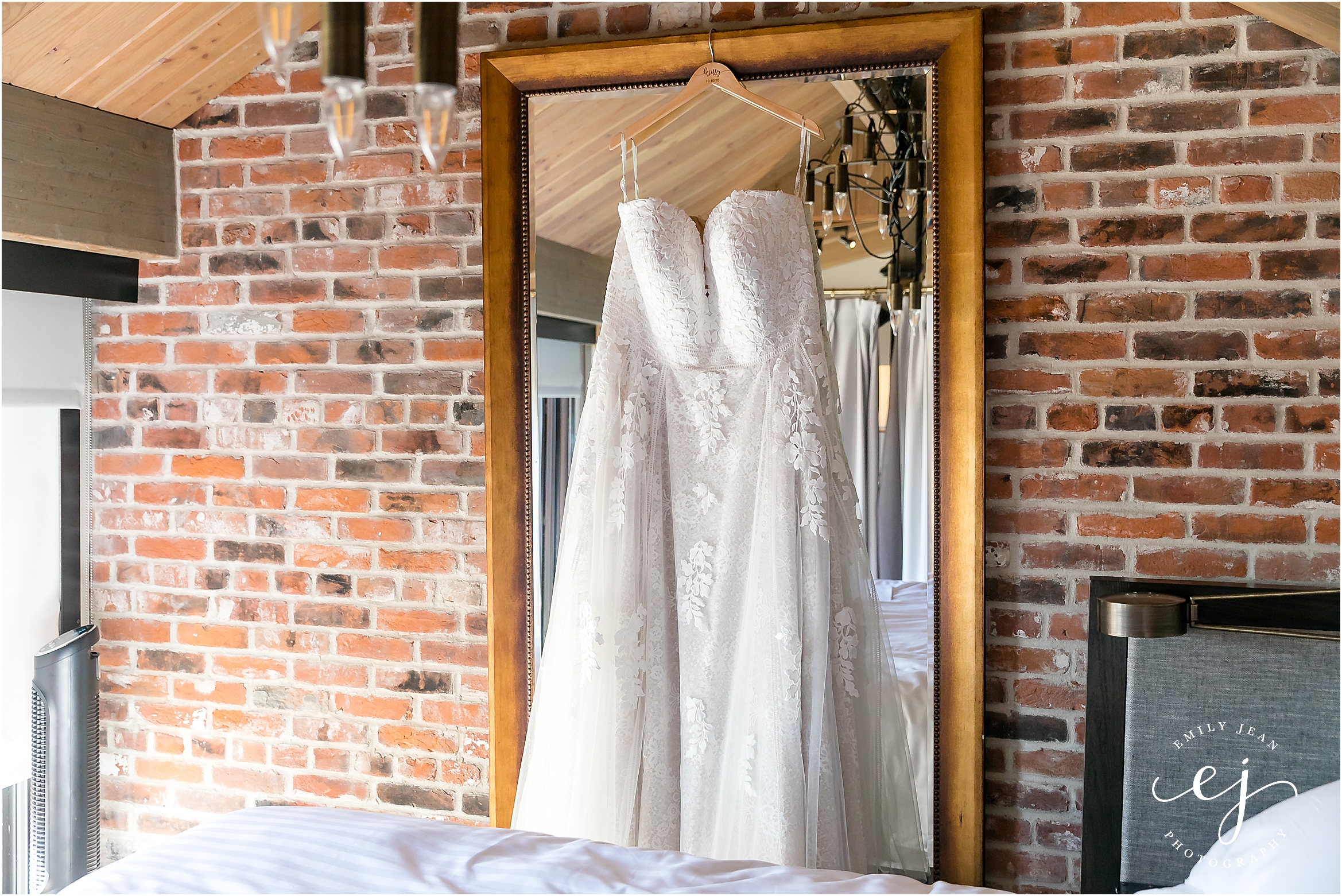 luxe wedding gown sweetheart with lace hanging from a mirror at the charmant