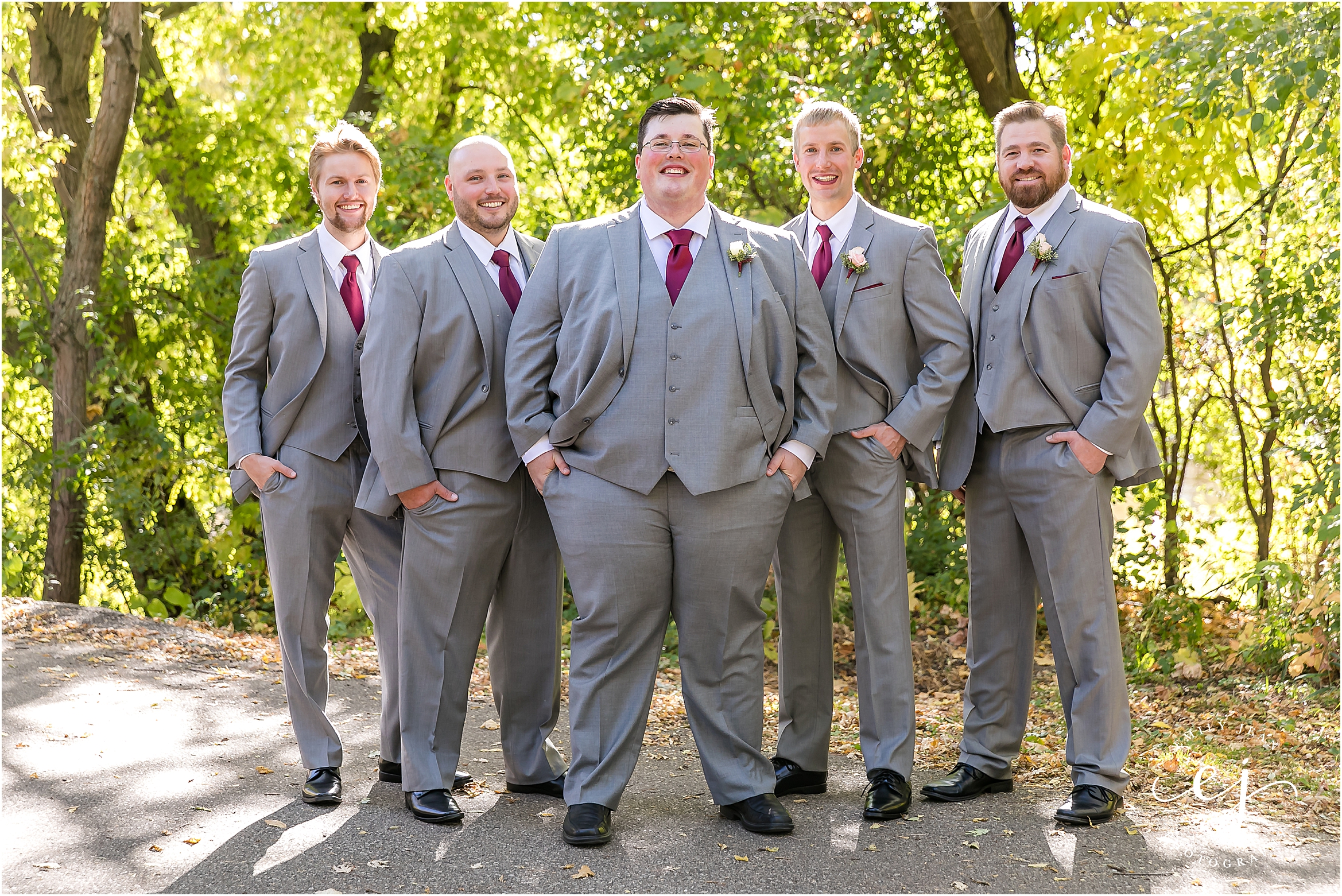 groomsmen in flying v formation with light grey suits and red ties