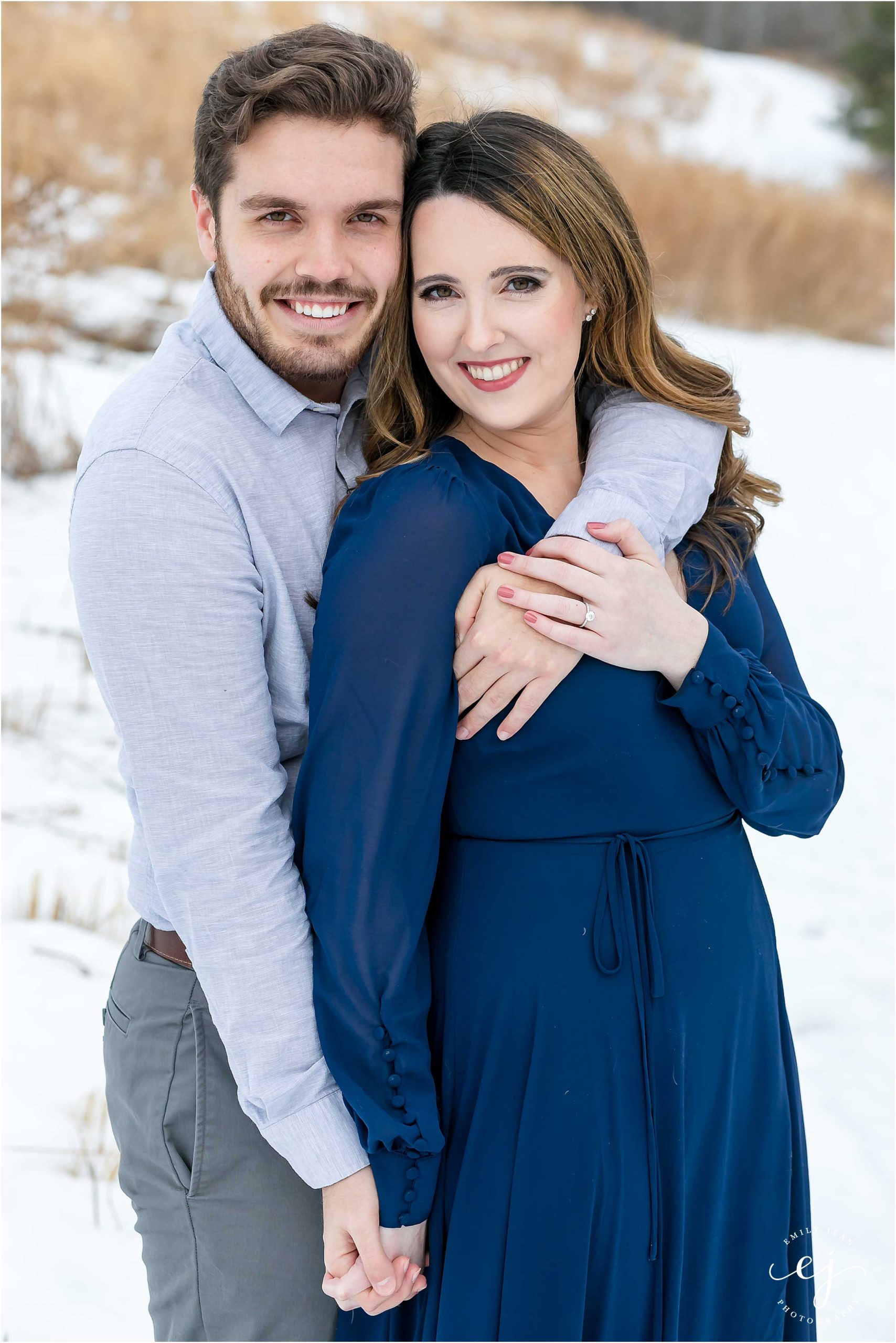 couple smiling at camera engagement photo wintertime in la crosse wisconsin rim of the city