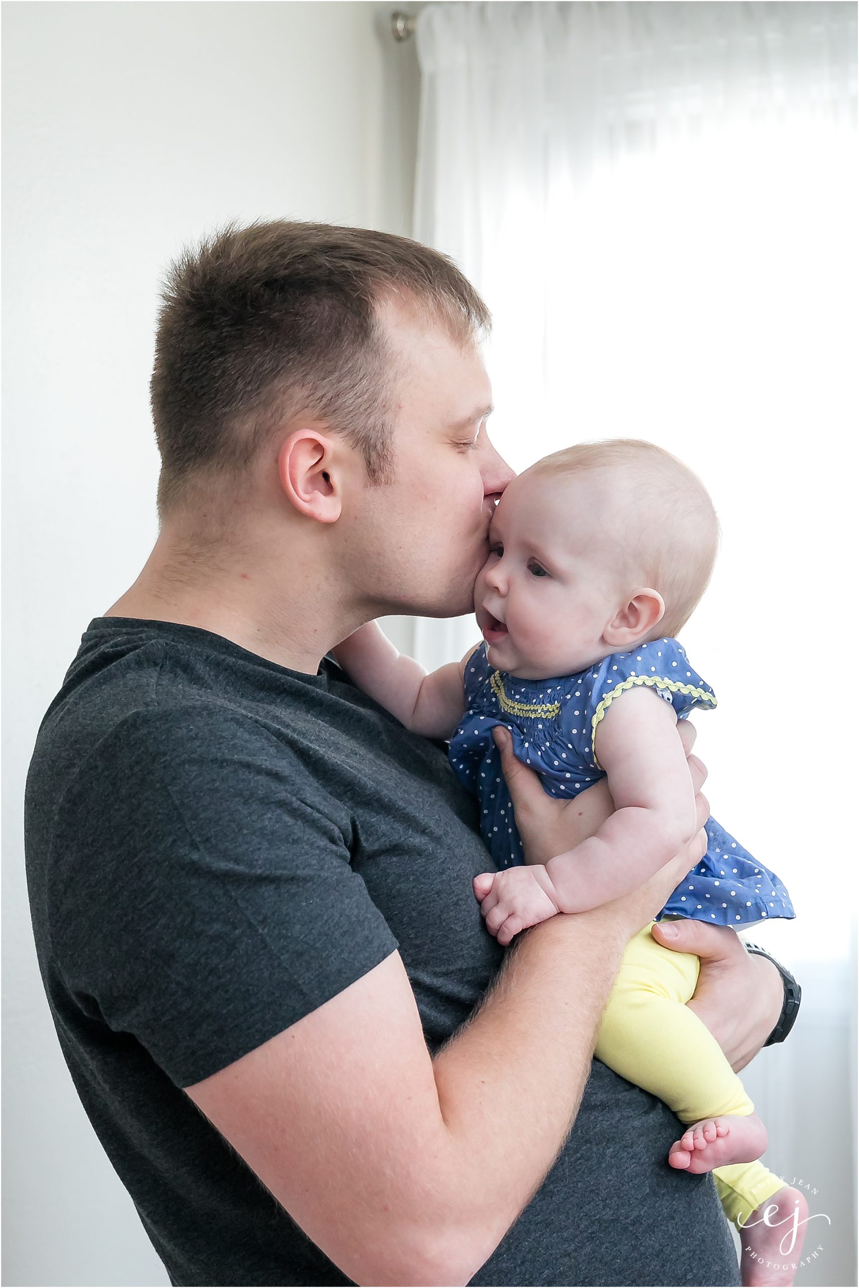 Daddy kissing baby daughter on the head