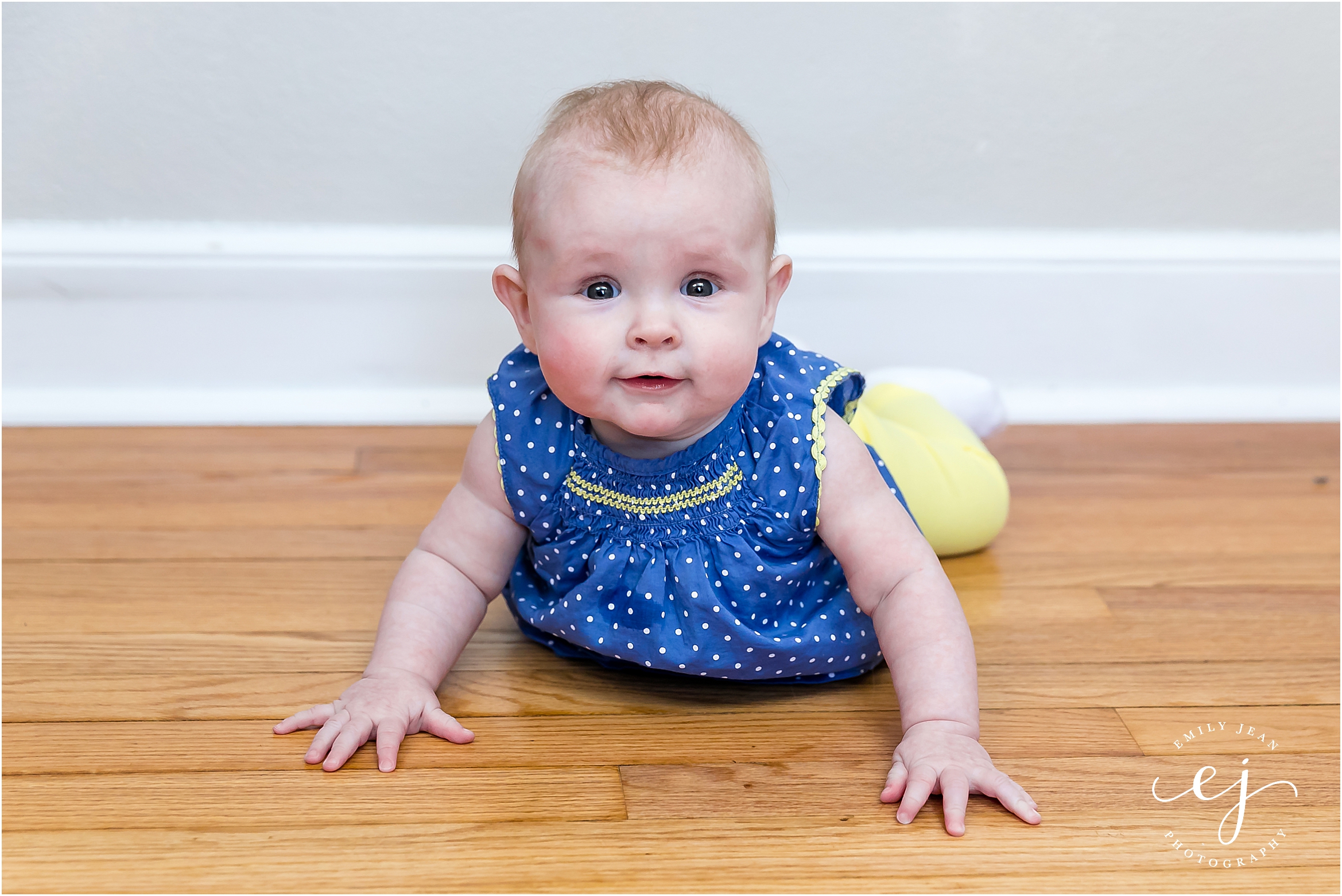 Smiling little baby girl on wood floor five month old portrait
