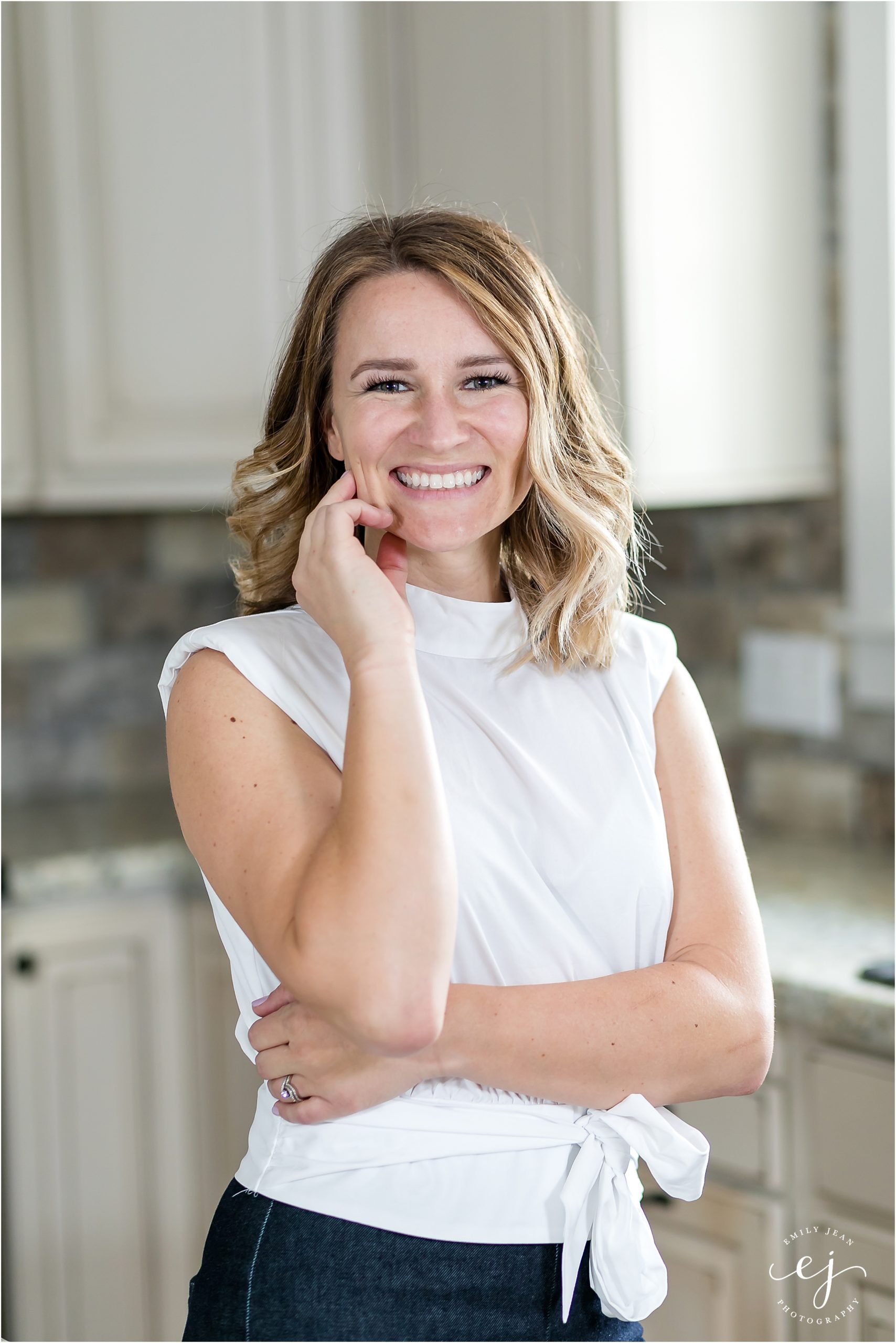 Young real estate agent headshot standing in kitchen branding photo