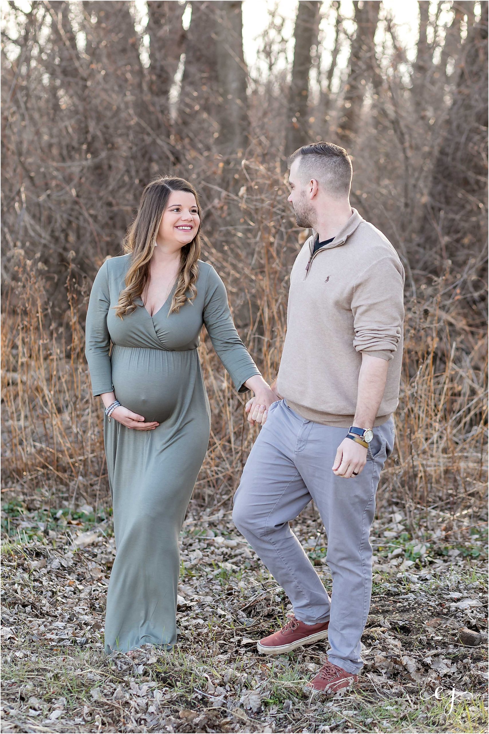 husband and wife walking in springtime at pettibone park pregnant