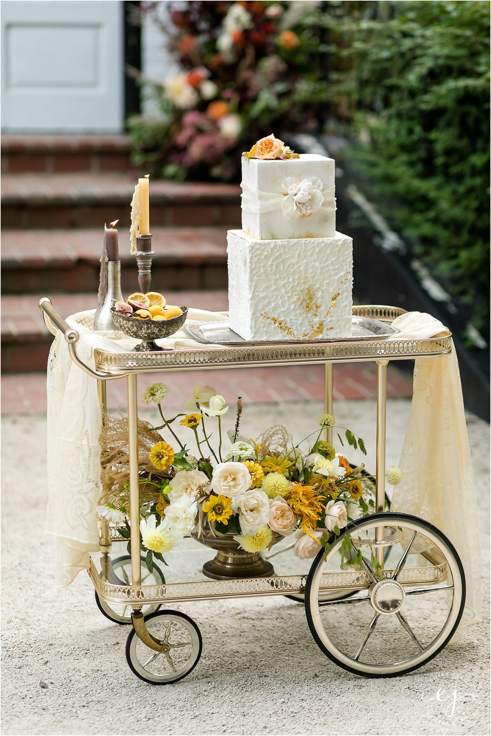 two tier square cake on a cart with flowers and candles maxwell mansion