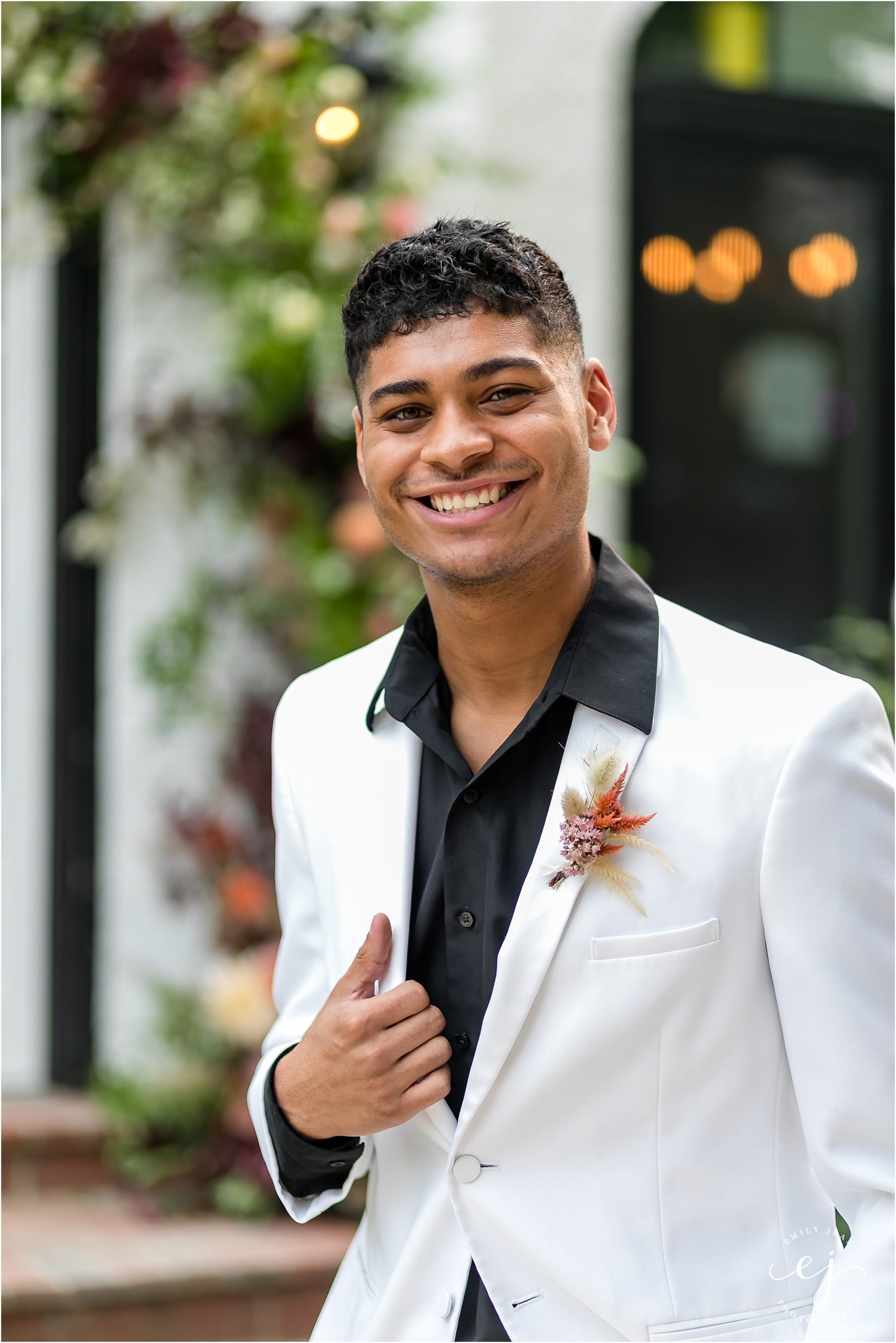 white suit and black shirt groom smiling