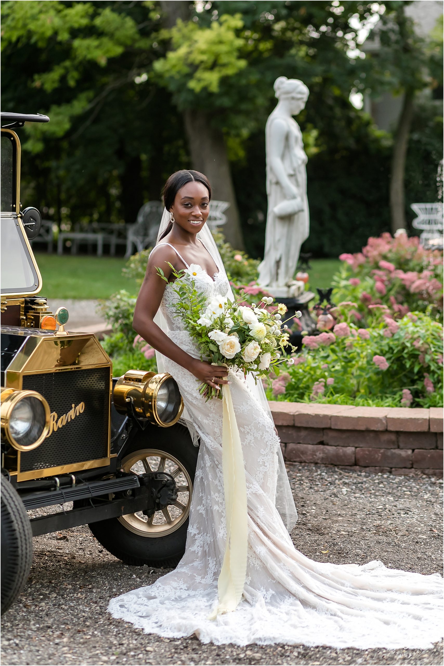 black bride with straight long hair standing with old car laughing