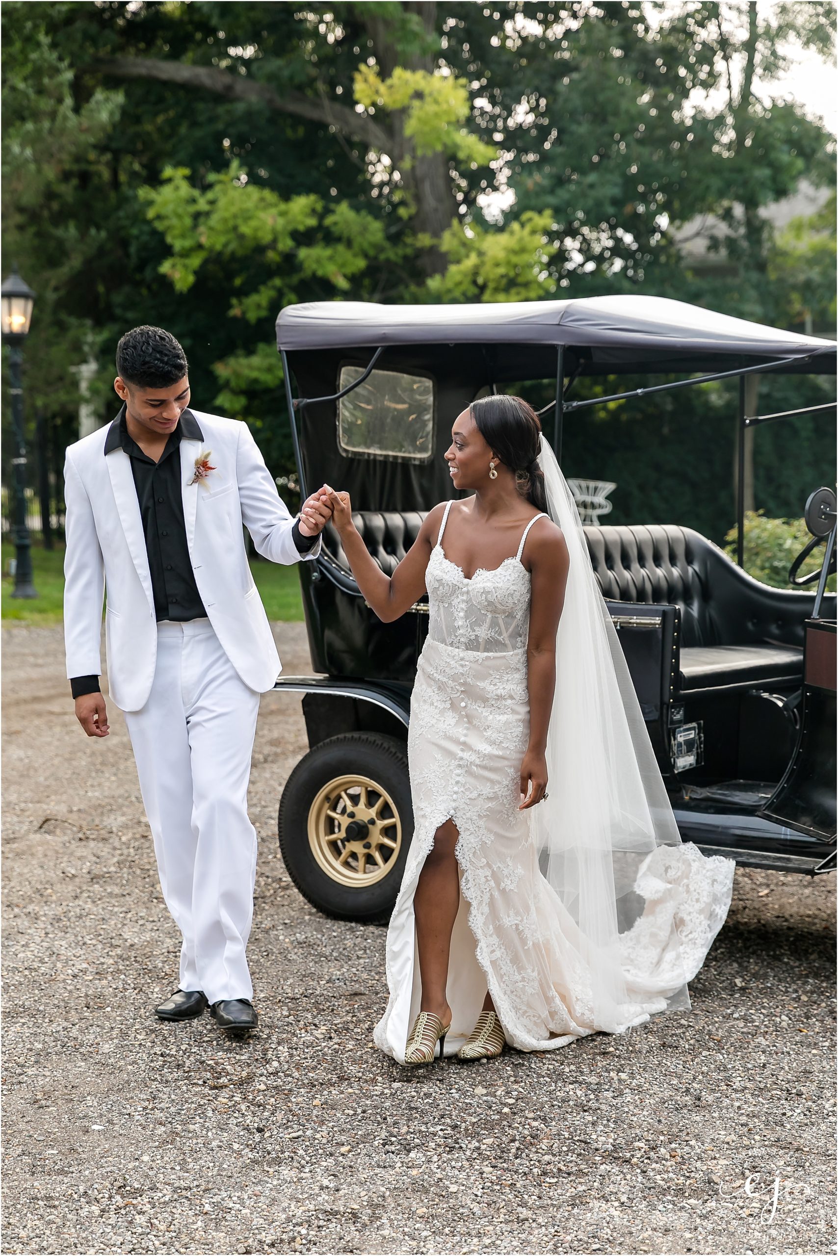 bride and groom walking past old car at maxwell mansion
