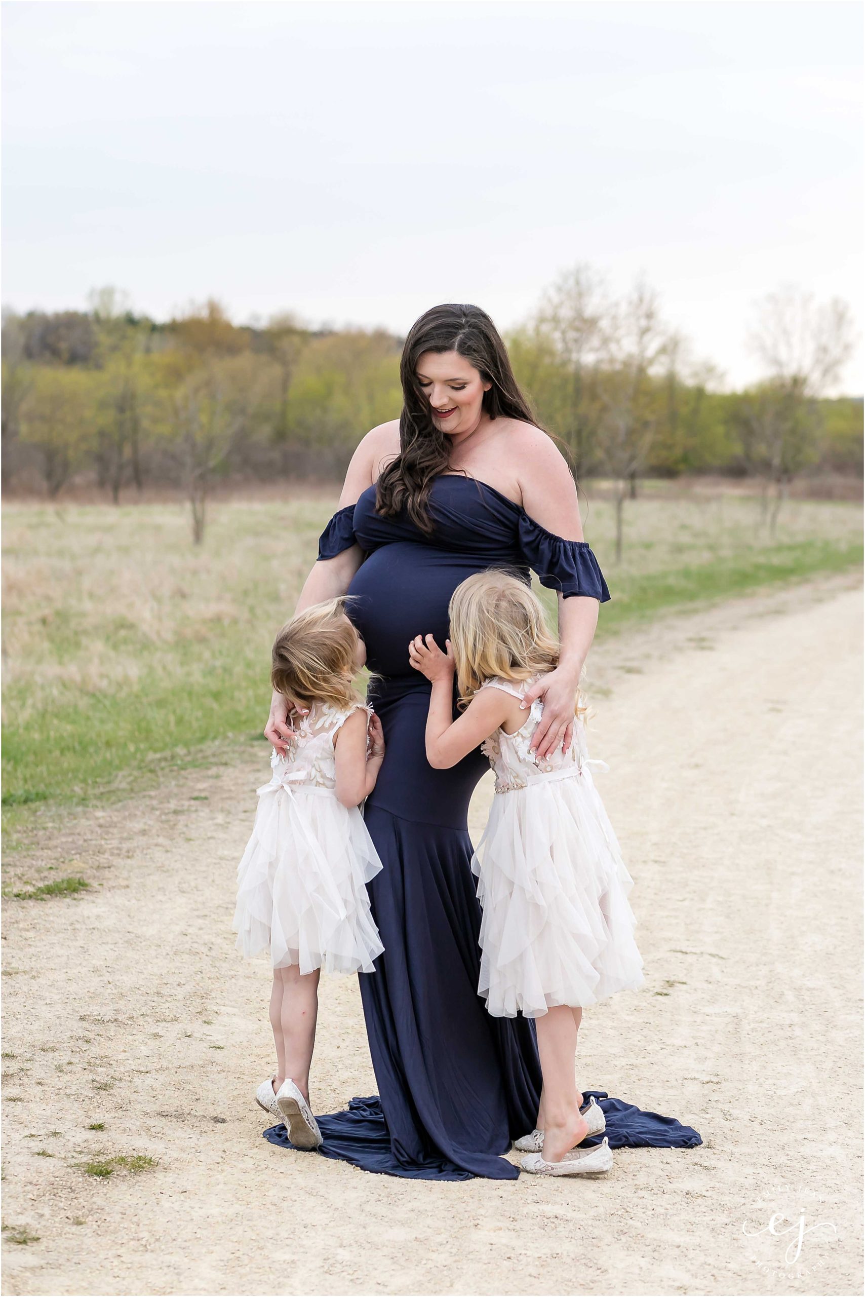 Little girls kissing moms belly at family photos in La Crosse Wisconsin