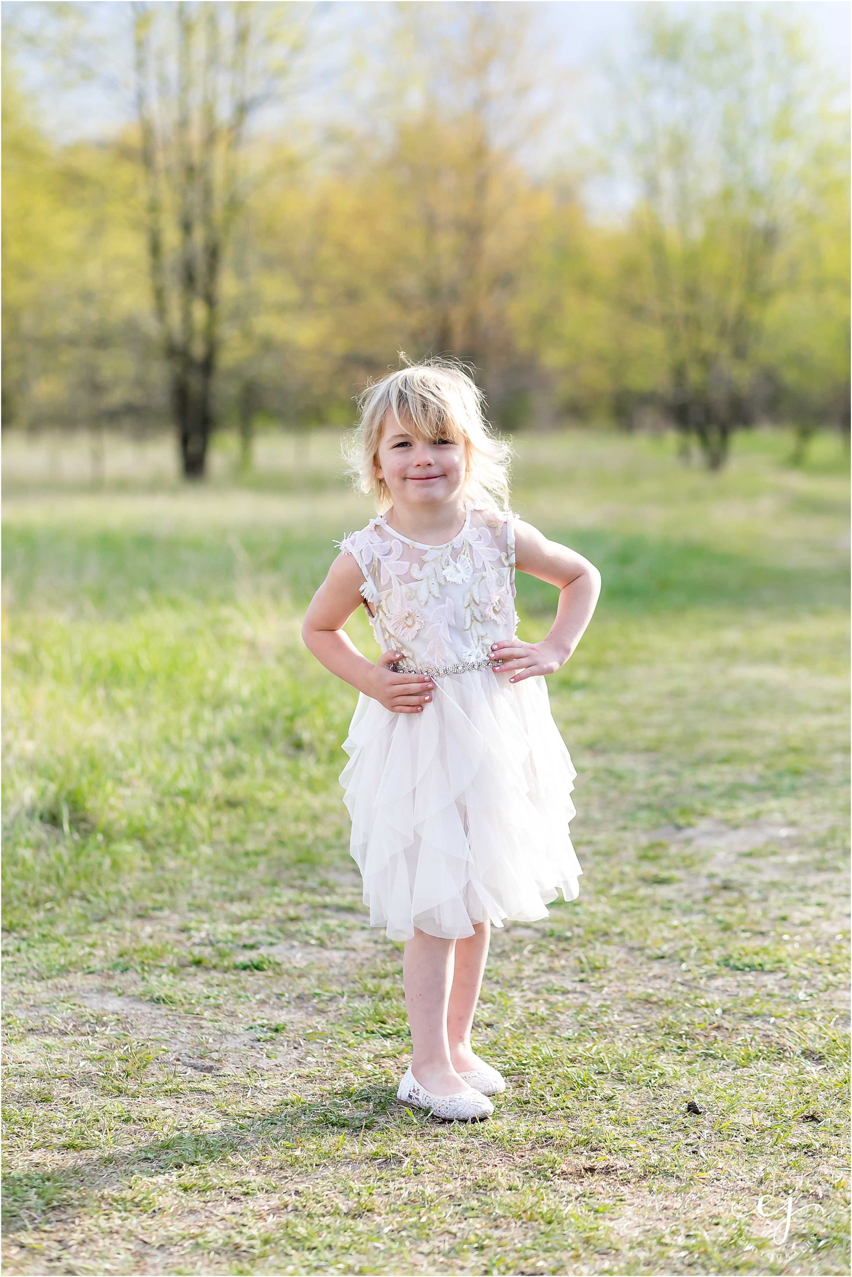 Little four-year-old girl dressed up for photos smiling at the camera and posing