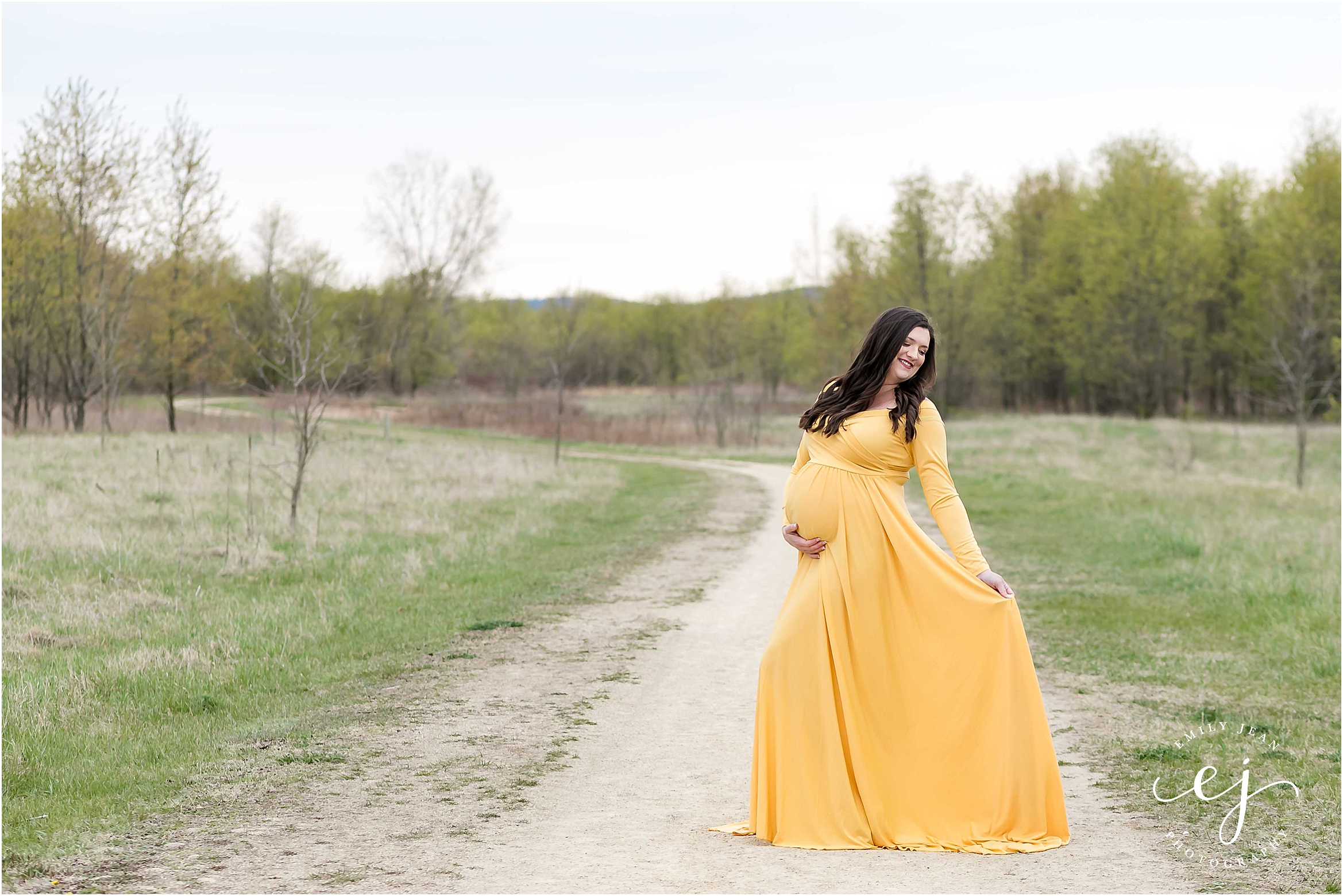 Pregnant women modeling a maternity dress on a gravel path