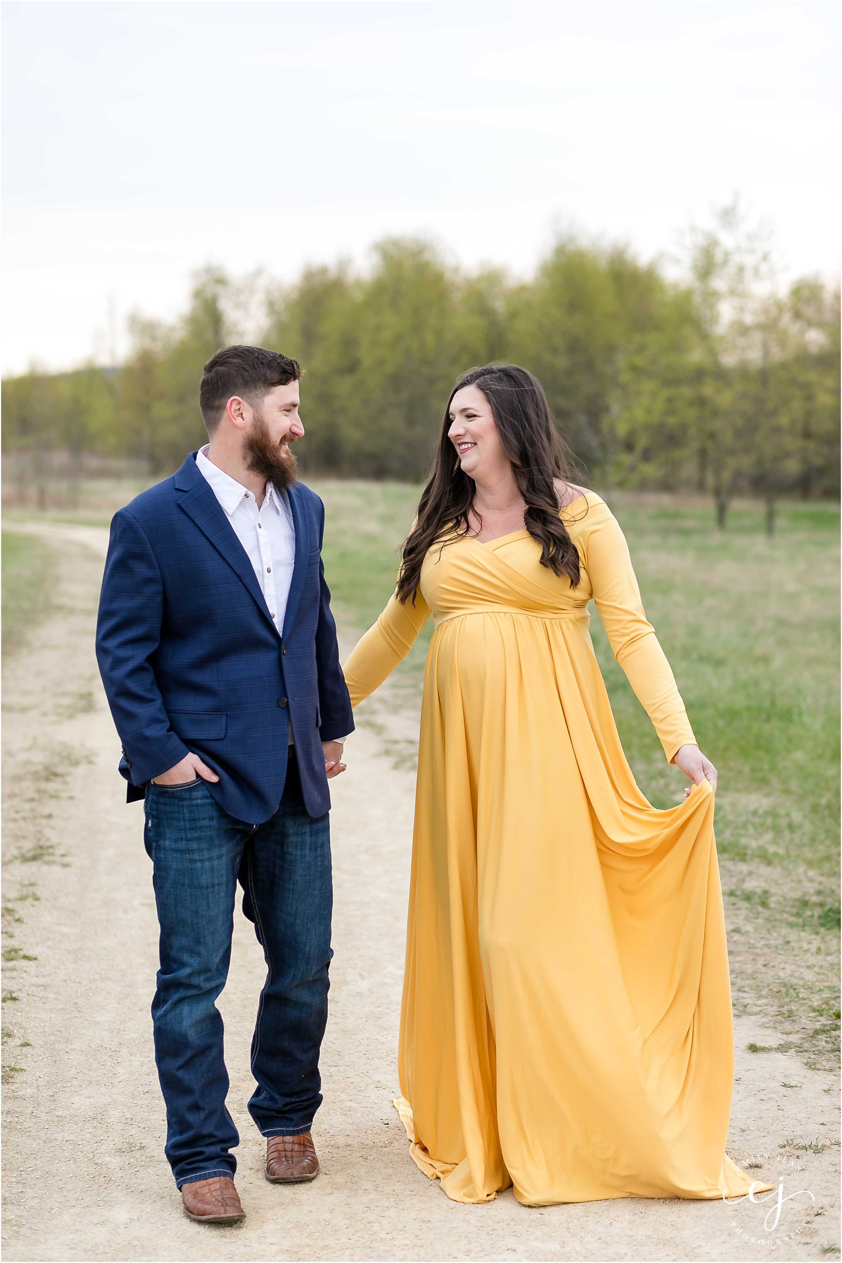 Man and woman holding hands walking maternity photo