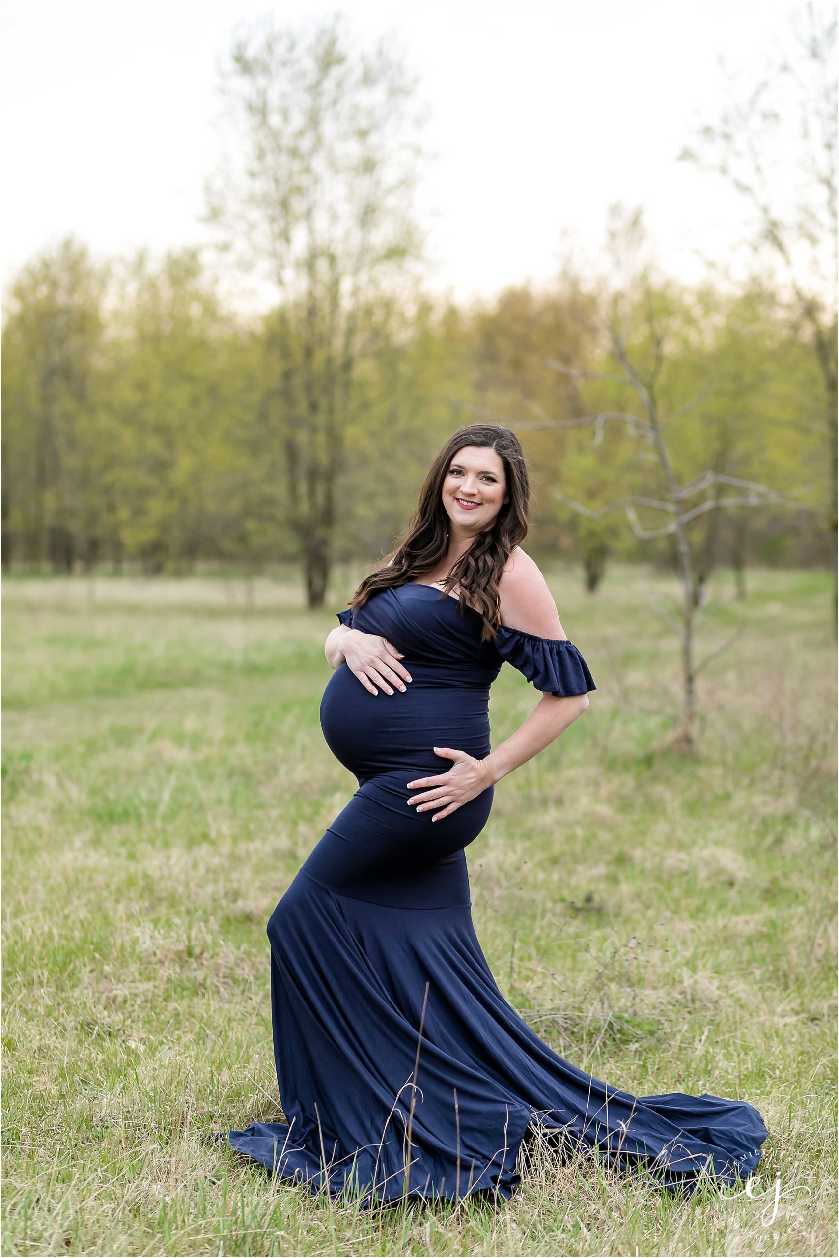 Maternity photoå navy blue off the shoulder dress in nature at sunset