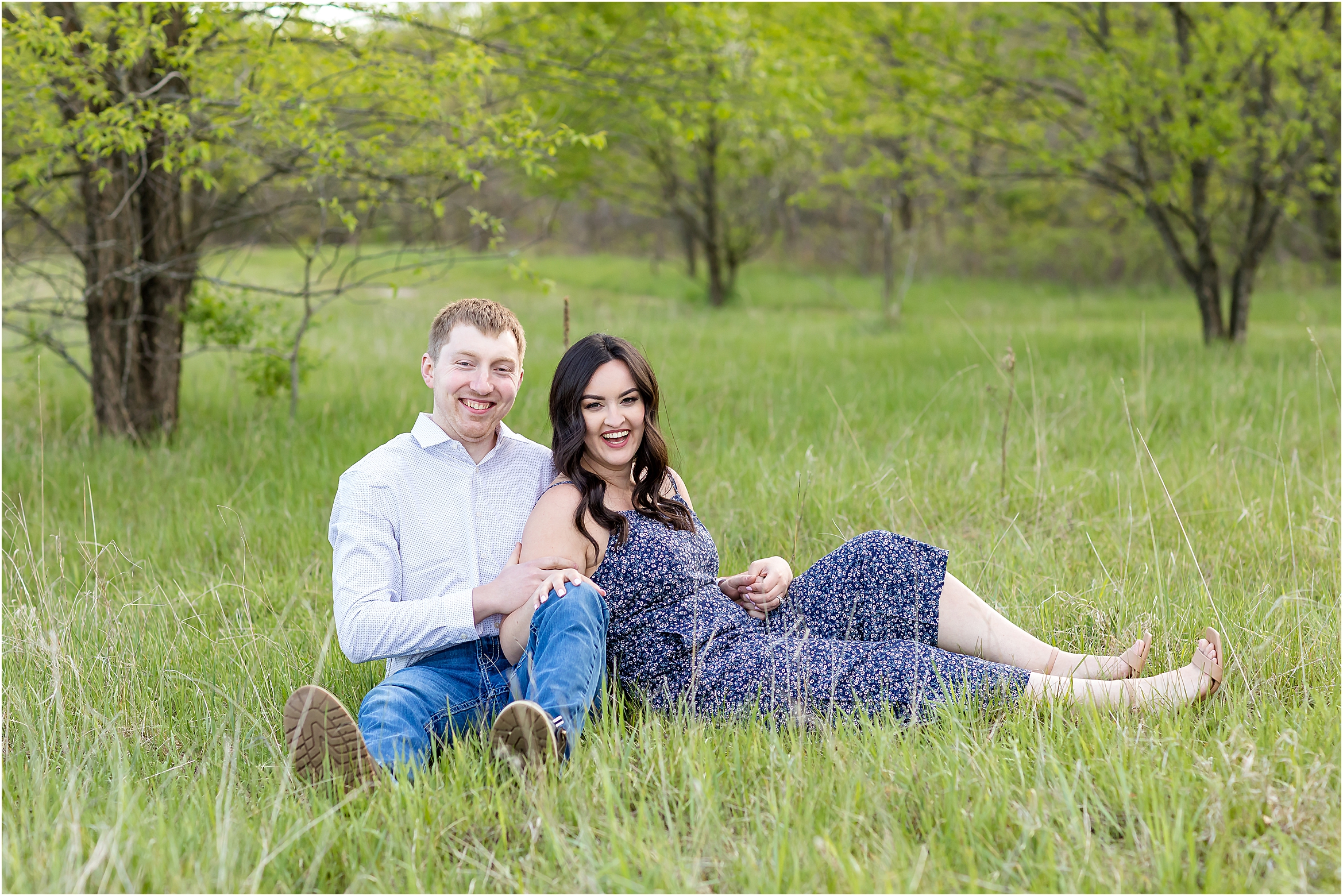man and woman laying in grass smiling