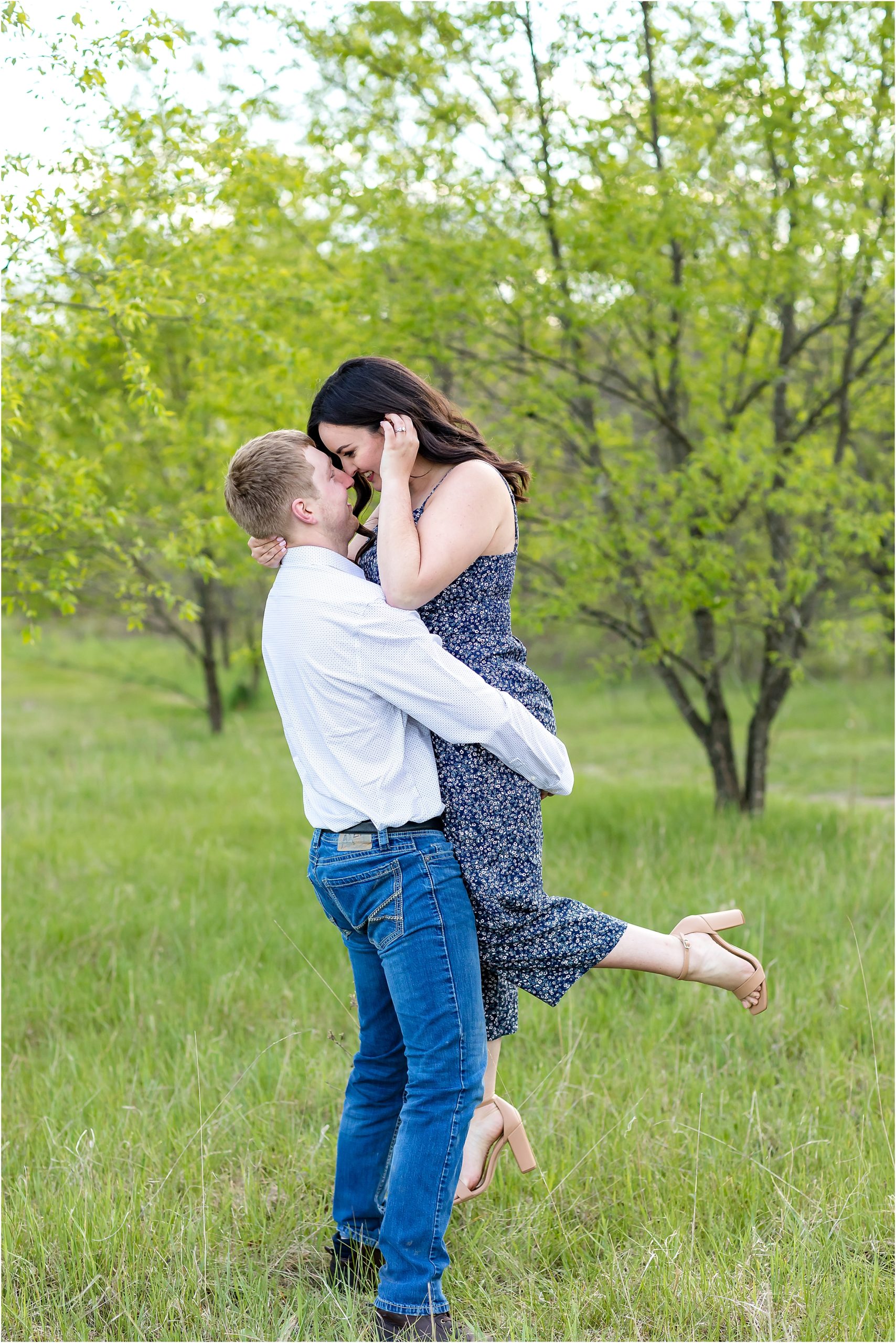 man picking up woman at engagement session