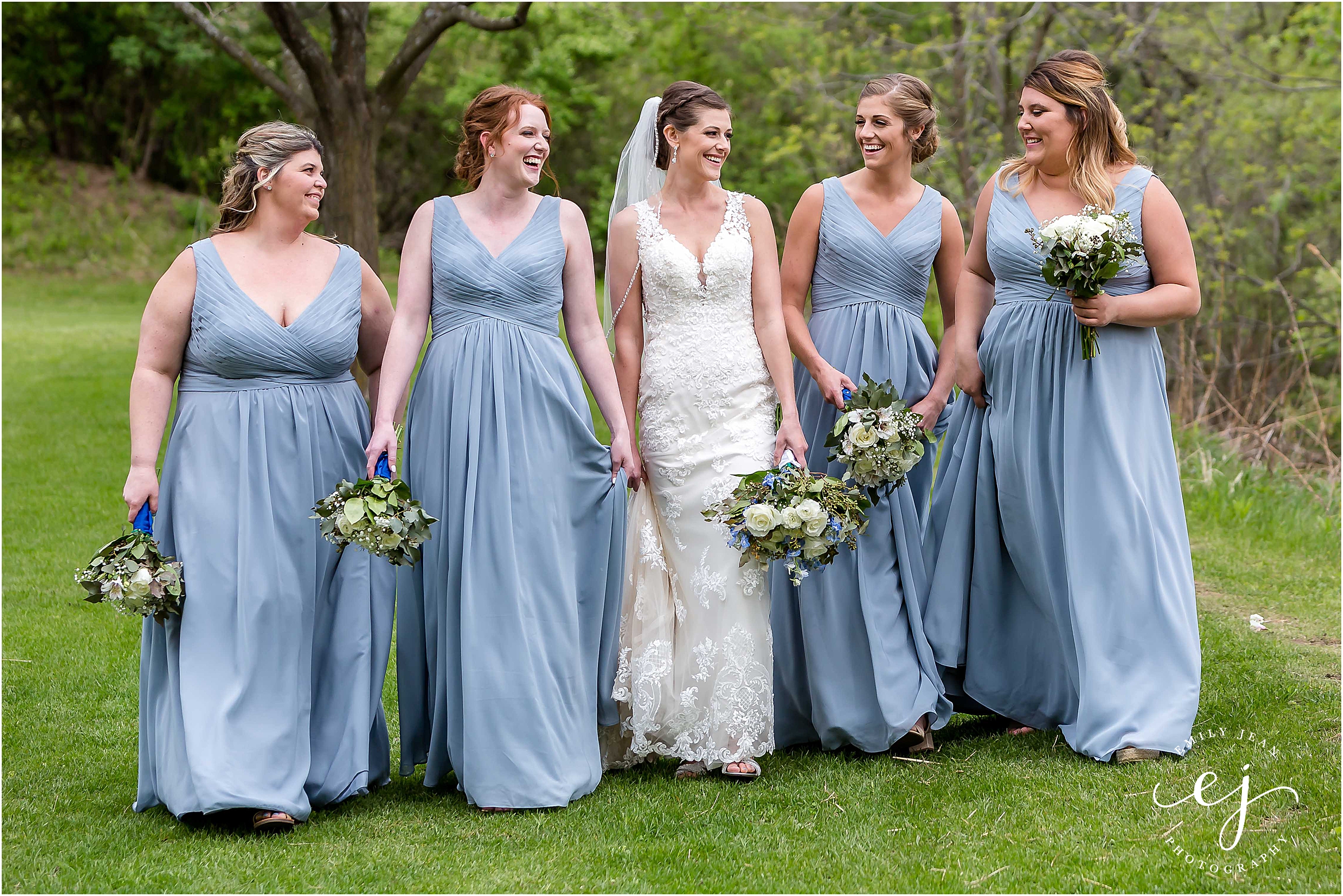 bridesmaids standing outside wearing dusty blue long dresses