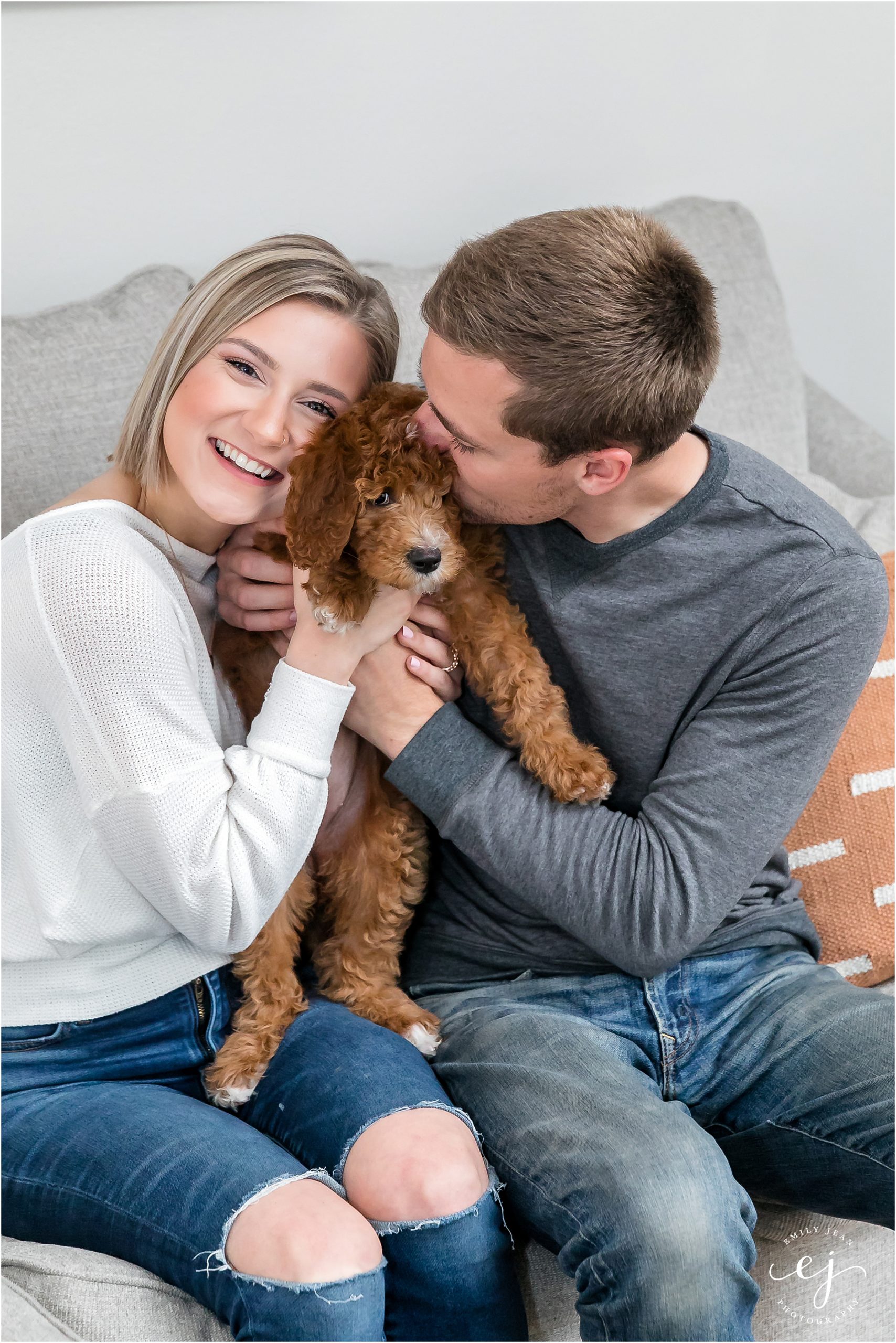 young couple snuggling new golden doodle puppy