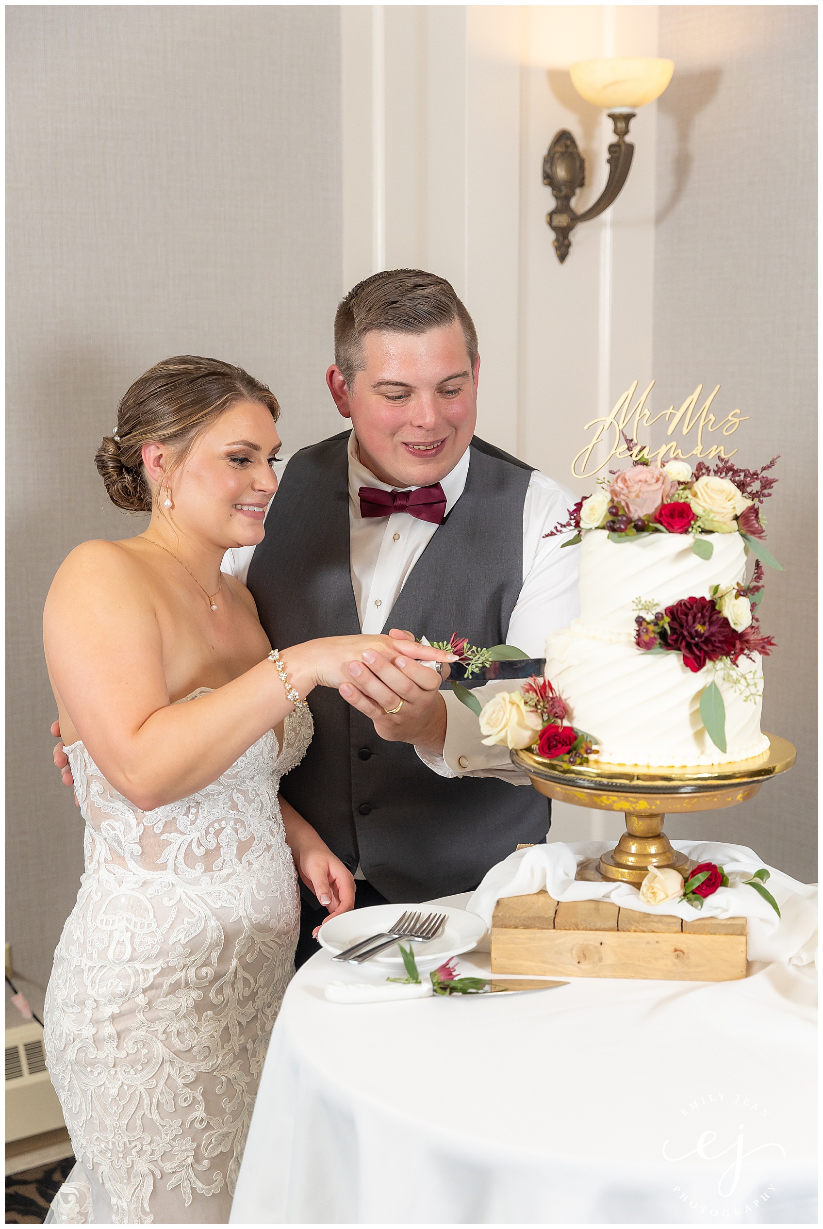 bride and groom cutting cake burgundy and gold elegant wedding