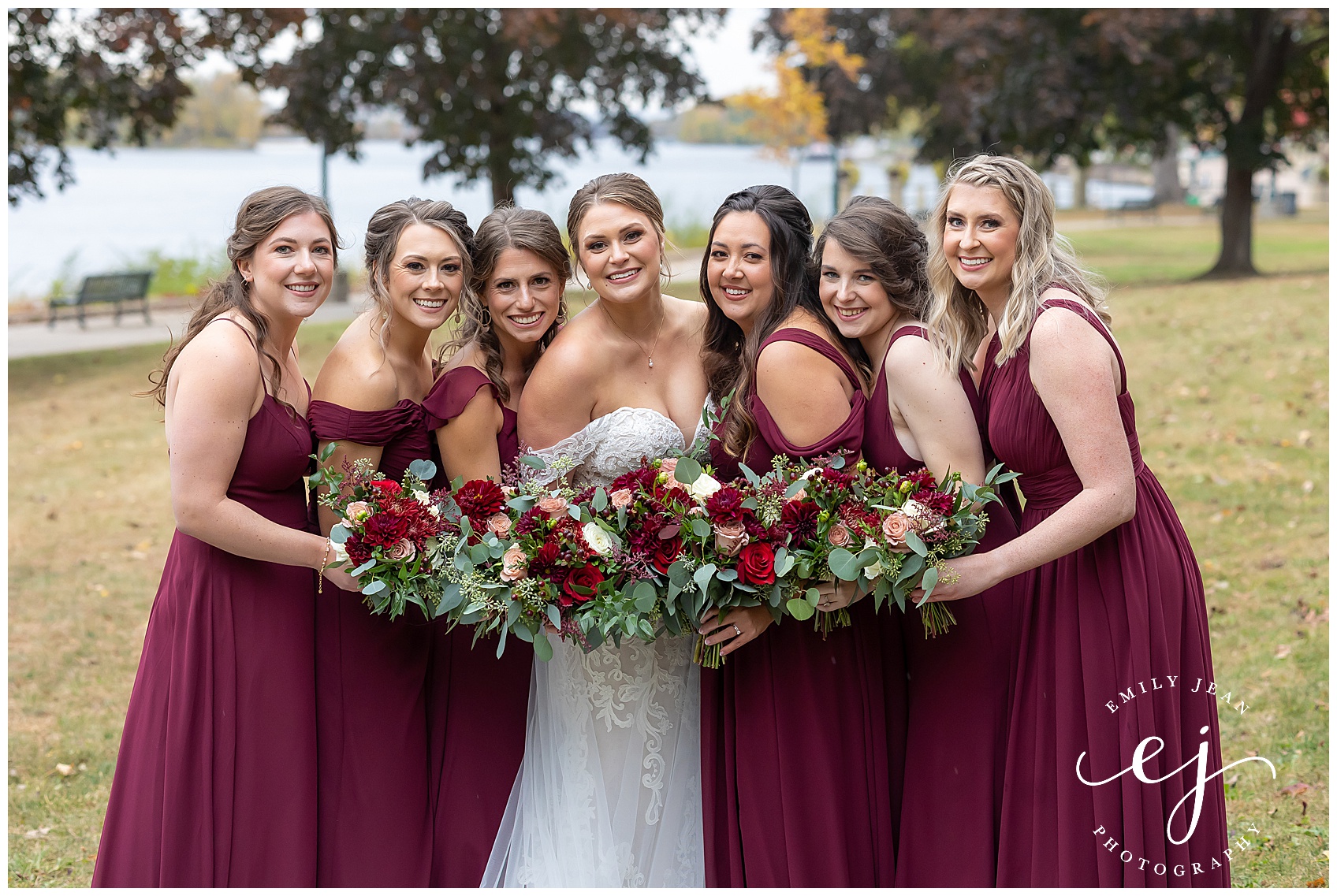burgundy bridesmaids with red flowers and greenery