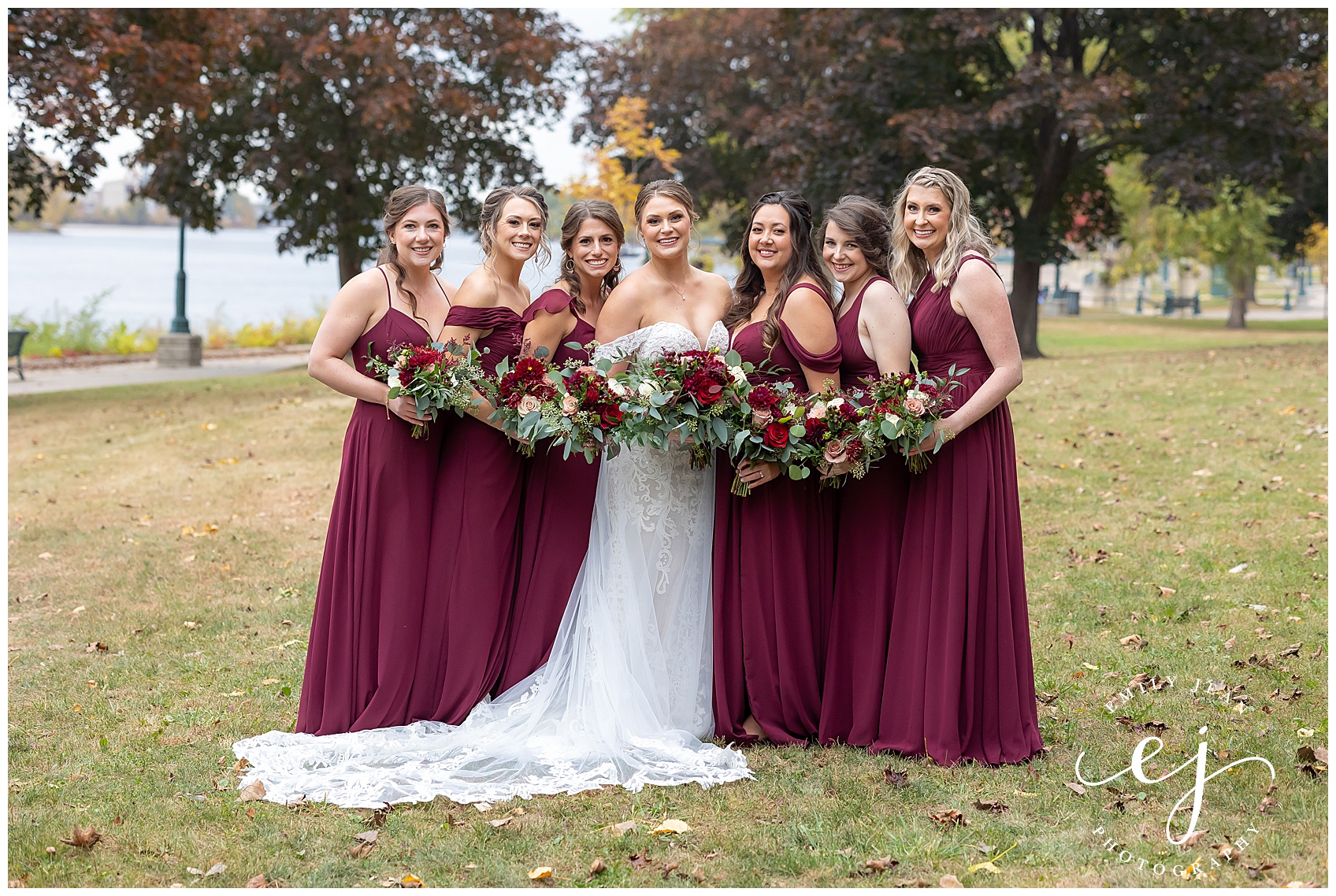 burgundy bridesmaids with red flowers and greenery