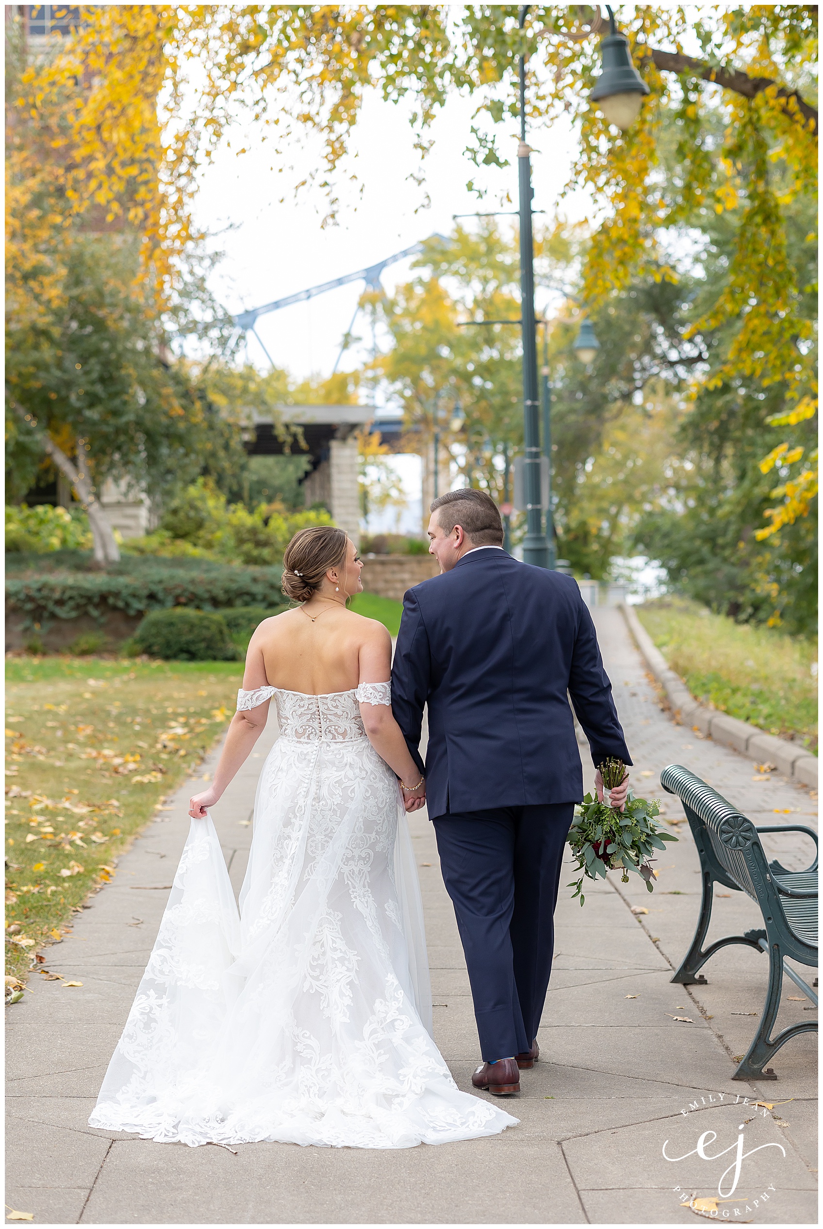 bride and groom walking down path navy and burgundy