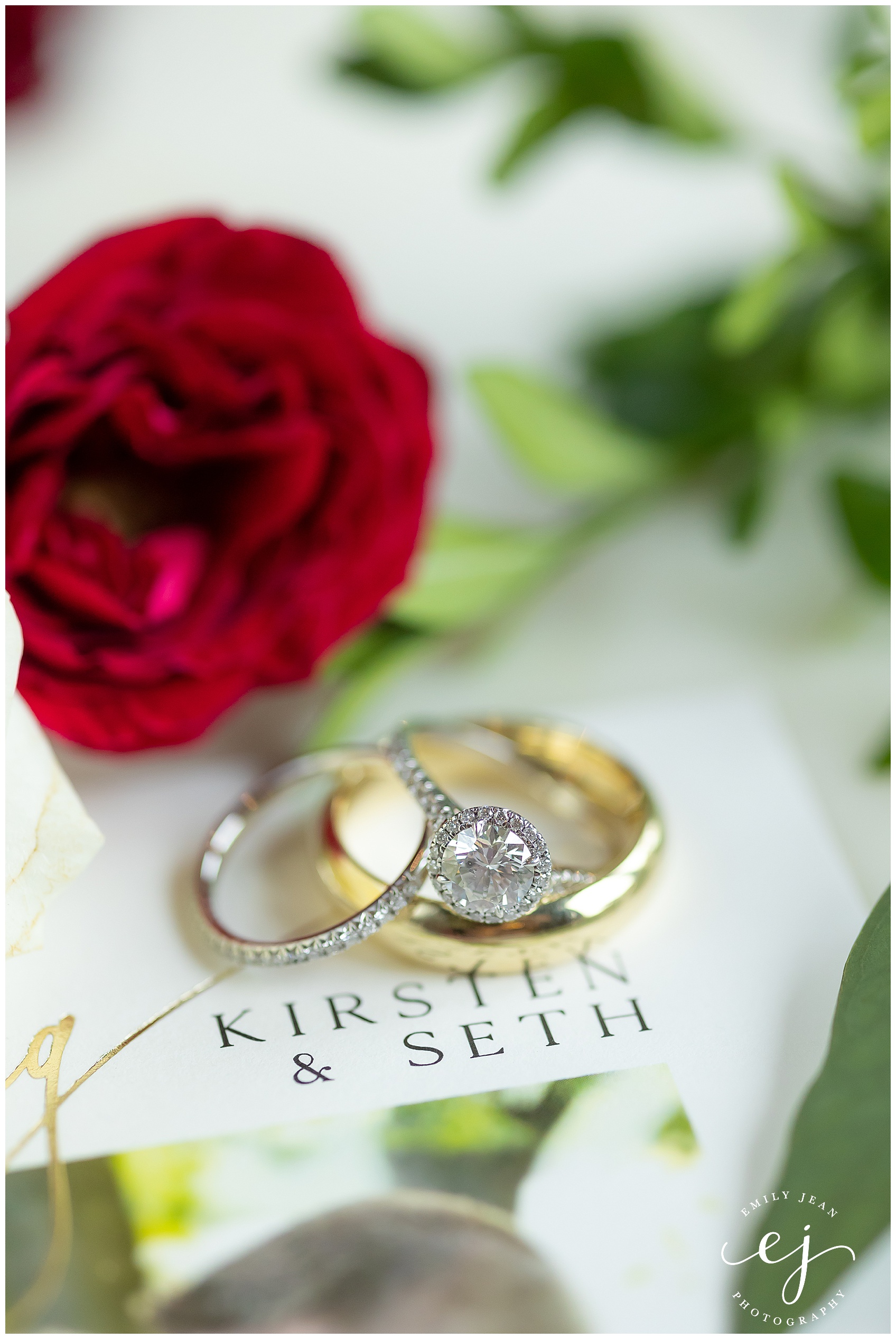 gold and silver wedding rings with flowers and invitation