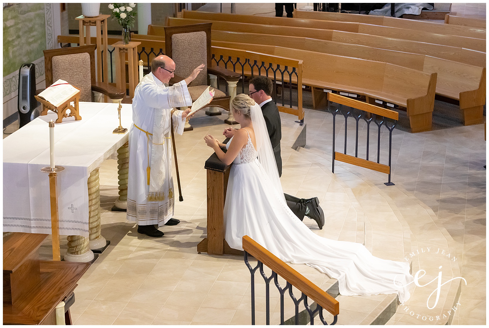 bride and groom receiving blessing during church service