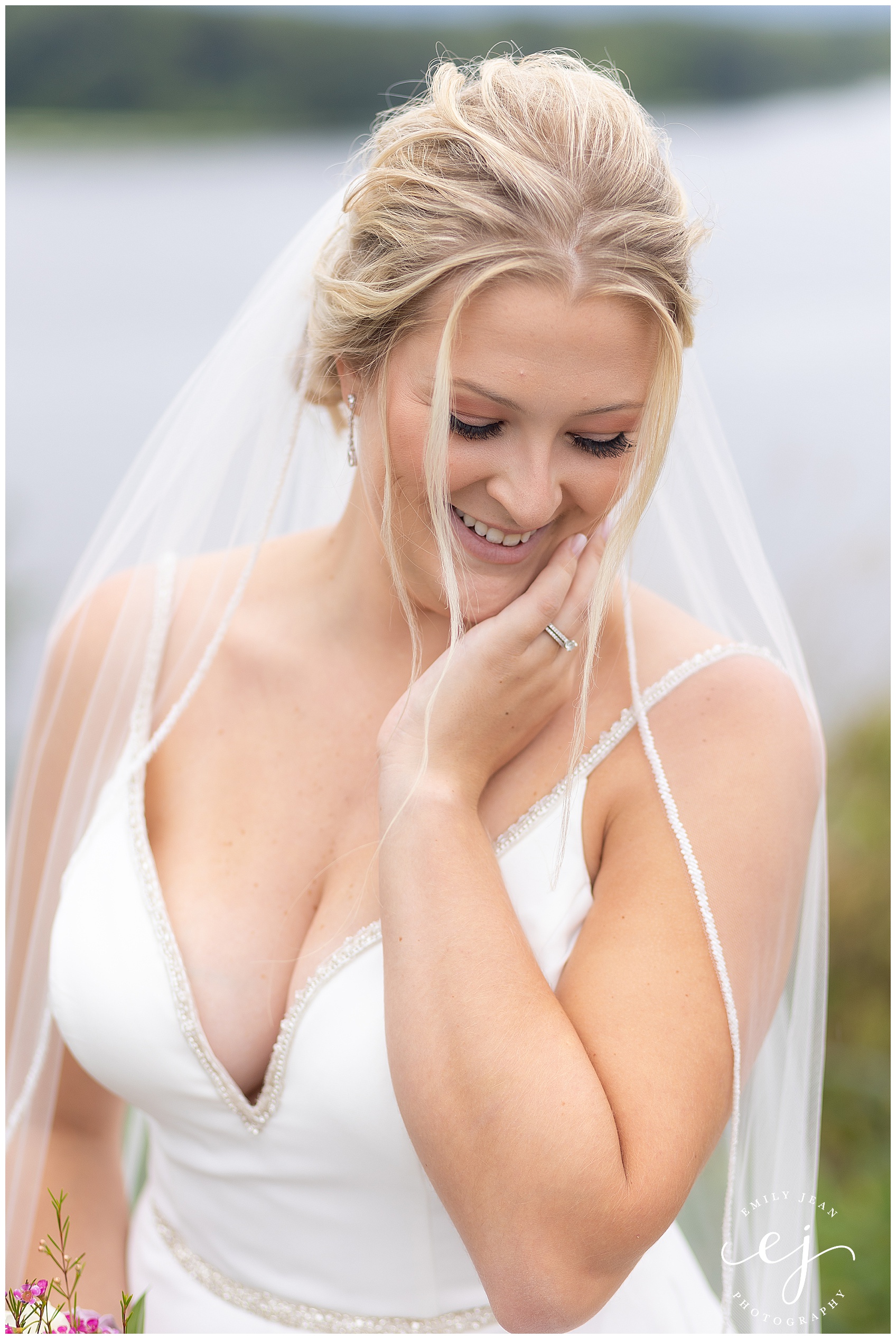 bride laughing and looking down smiling deep v-neck dress with veil