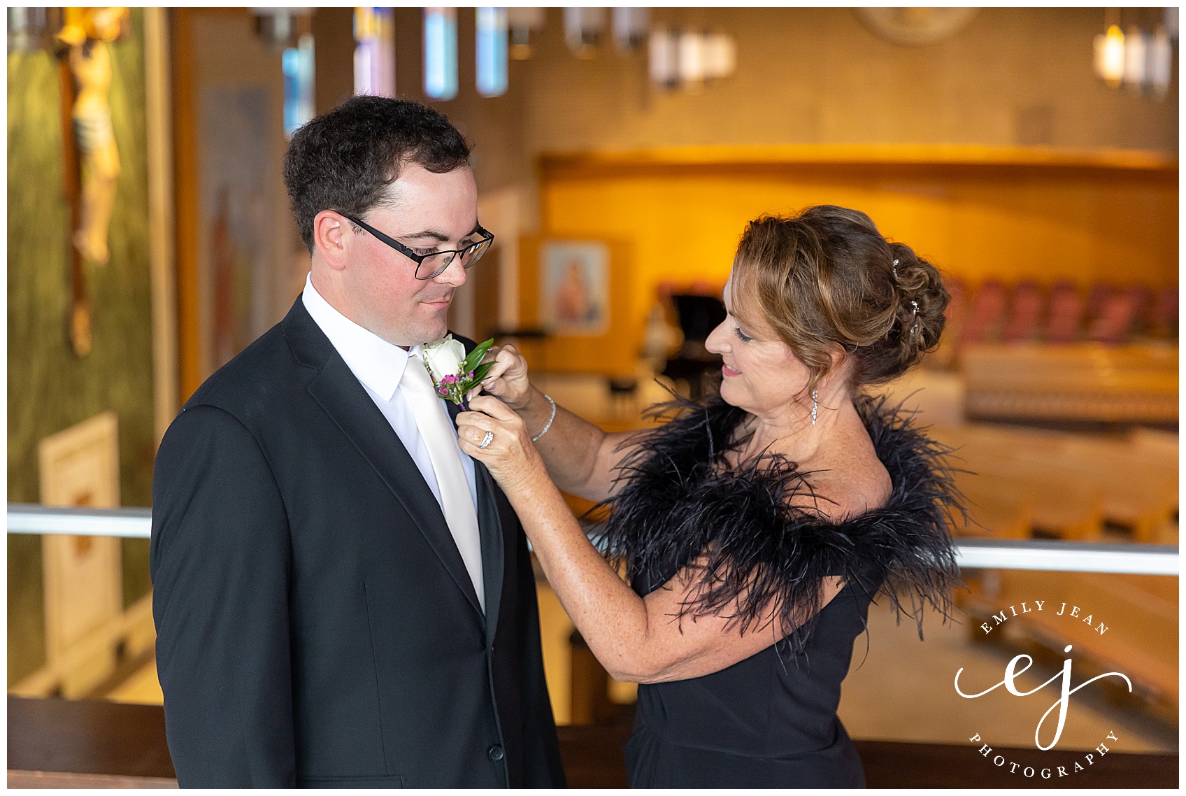 grooms mom putting boutonniere on son