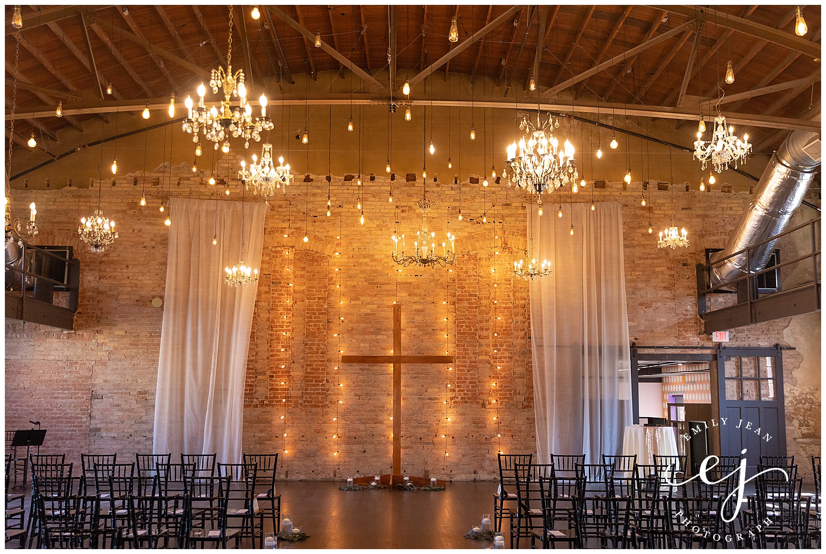 large cross chandelier and brick wedding ceremony space