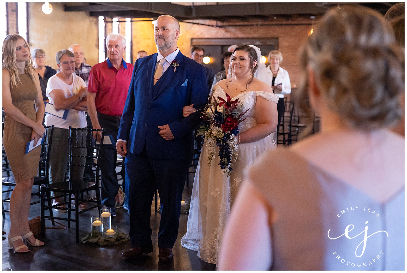 bride and her dad walking up the aisle while her mom looks