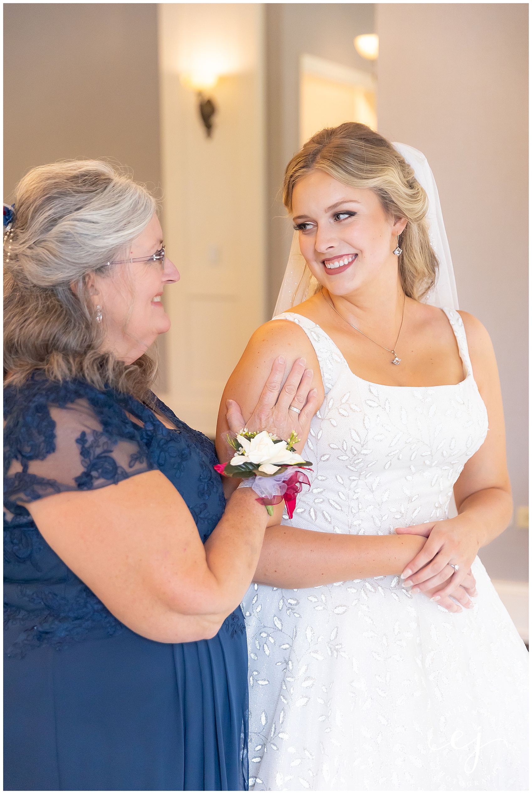 sweet moment of mom and daughter getting ready for wedding