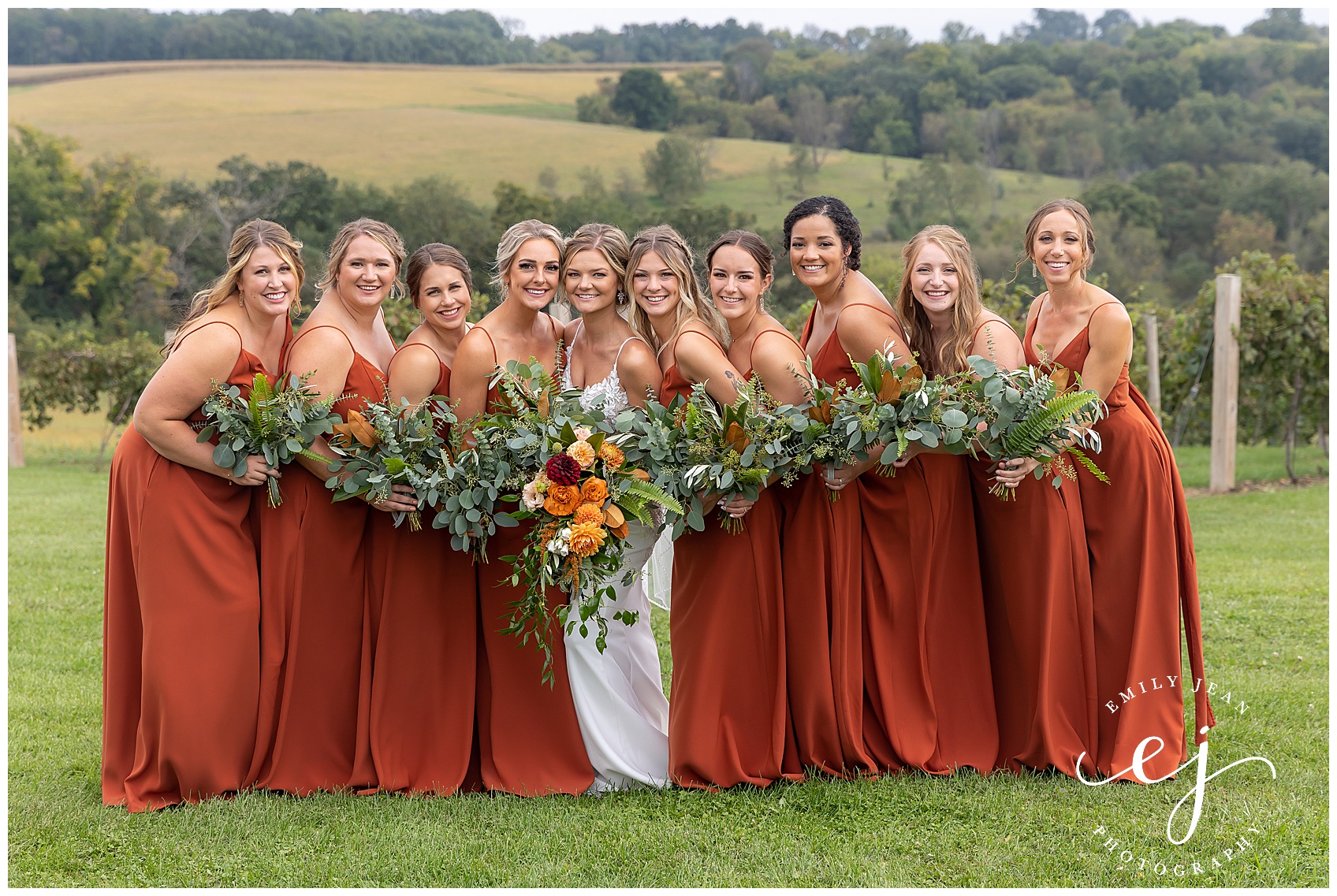 bridesmaids in burnt orange autumn dresses with greenery bouquets