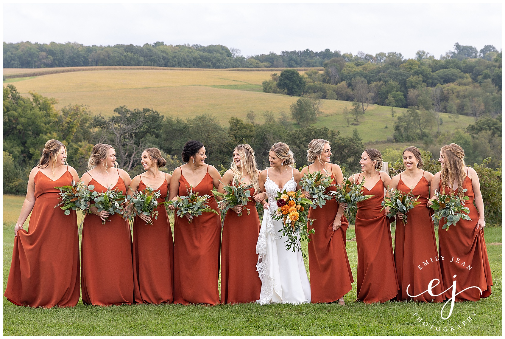 bridesmaids in burnt orange autumn dresses with greenery bouquets