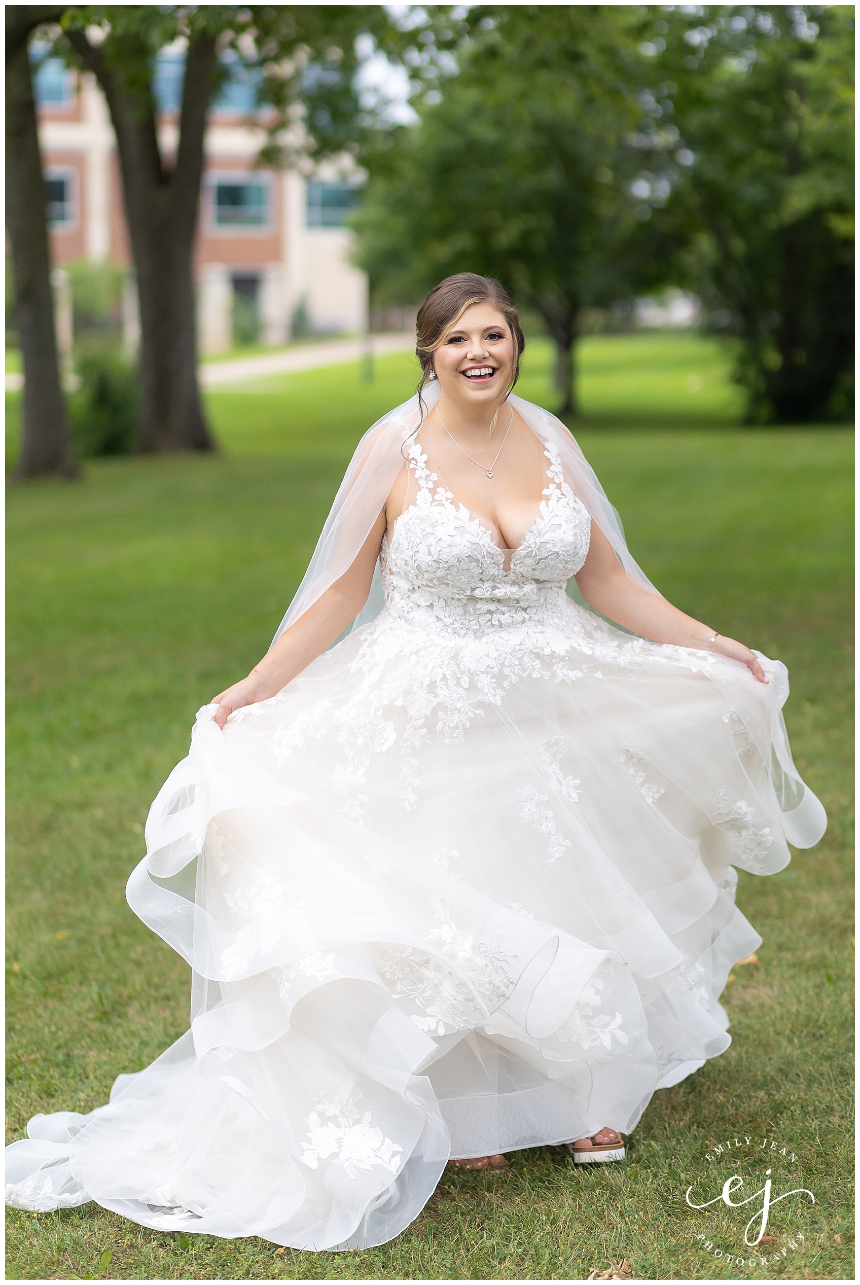 bride twirling in flowy lace dress in field