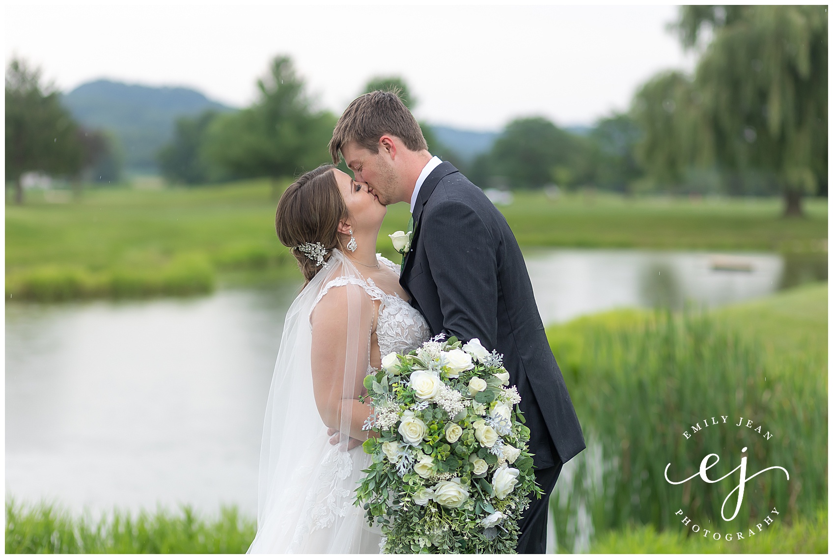 bride and groom portrait kissing along water at fox hollow golf course west salem wisconsin