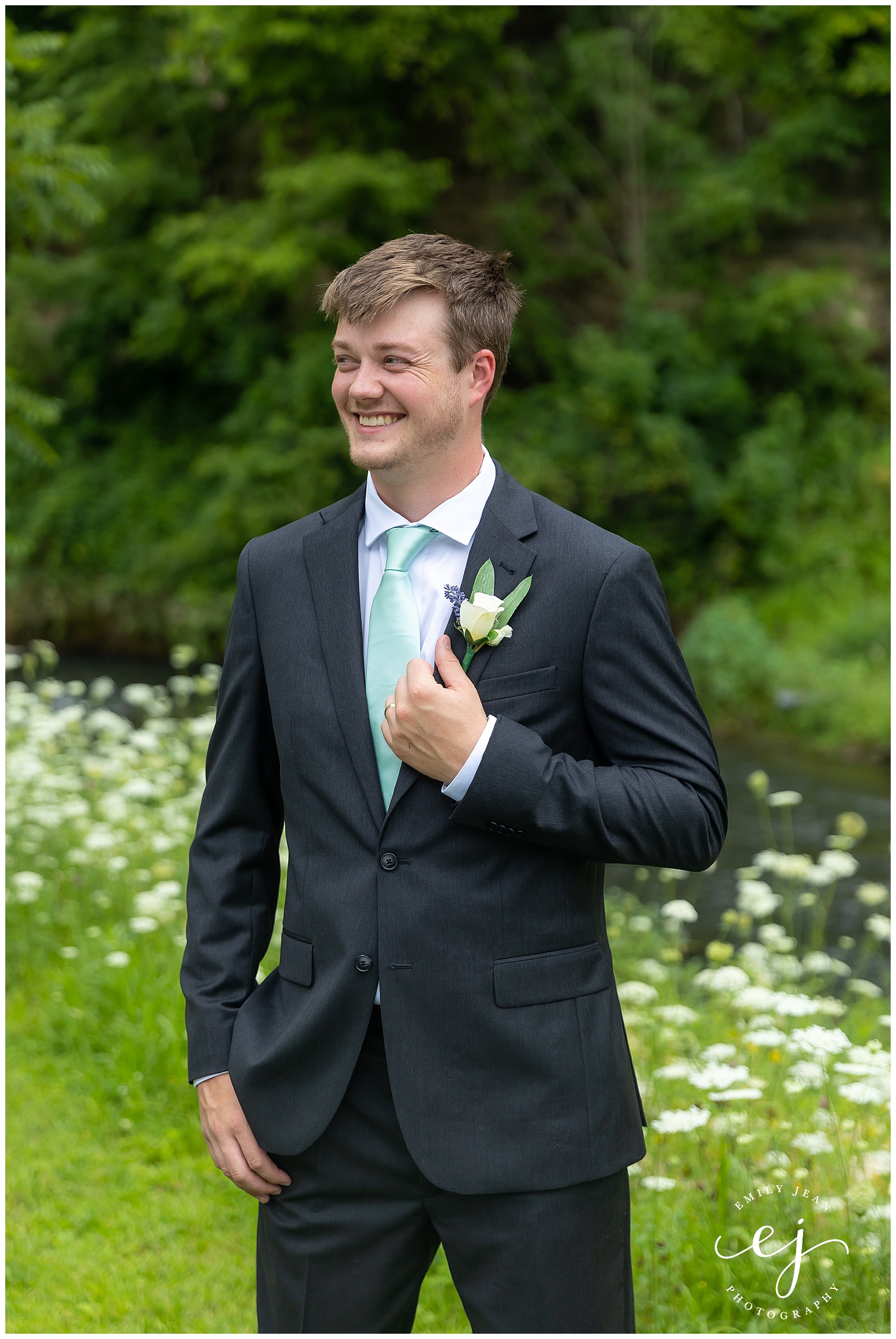 groom smiling wearing blue tie and grey suit